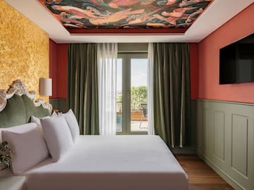 a bed in a room with a painting on the ceiling