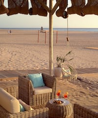 a beach with chairs and a table