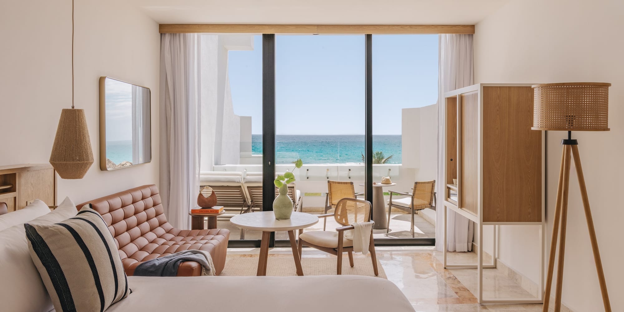 Modern ocean view resort suite with balcony and stylish decor.