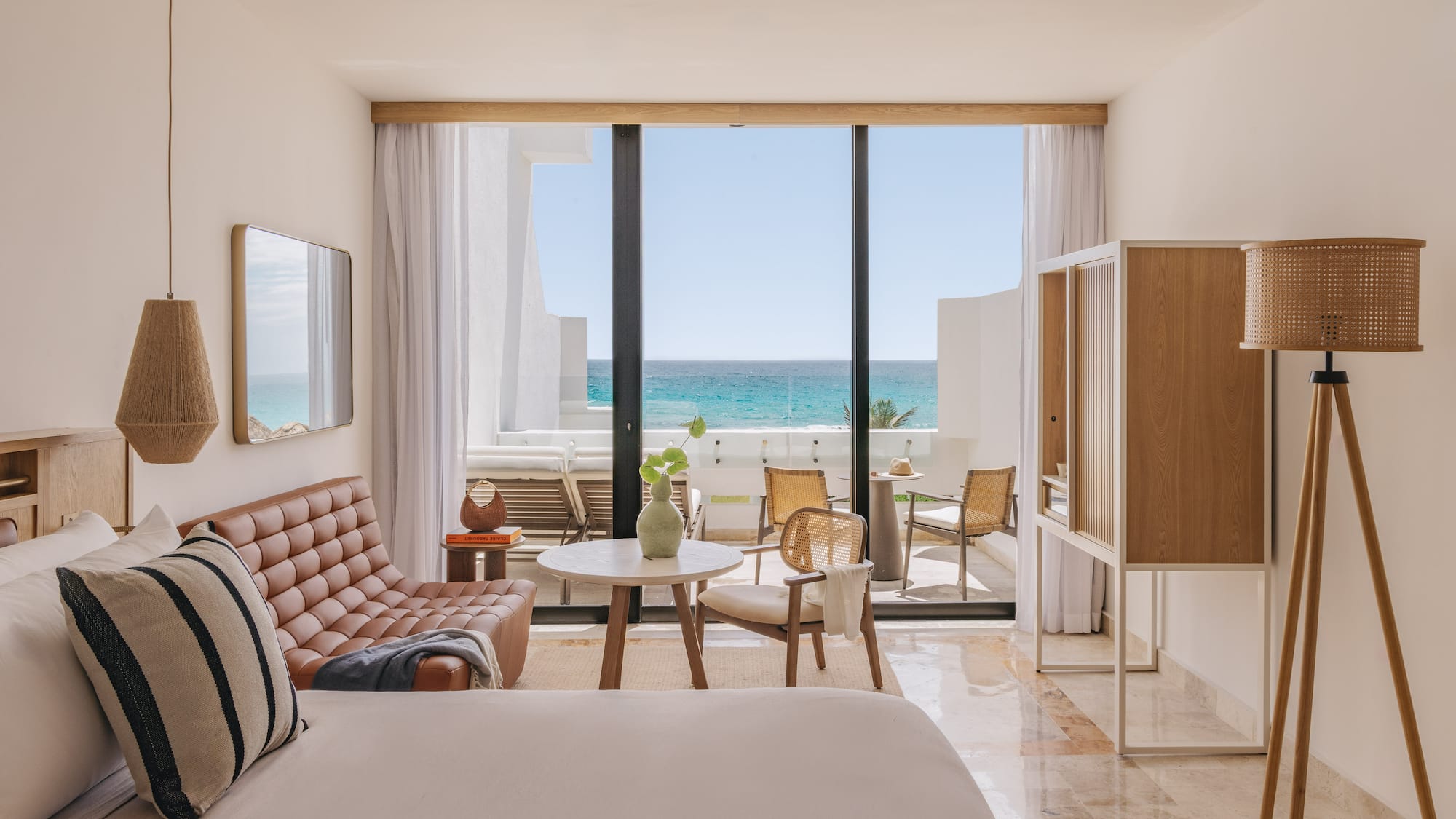 Modern ocean view resort suite with balcony and stylish decor.