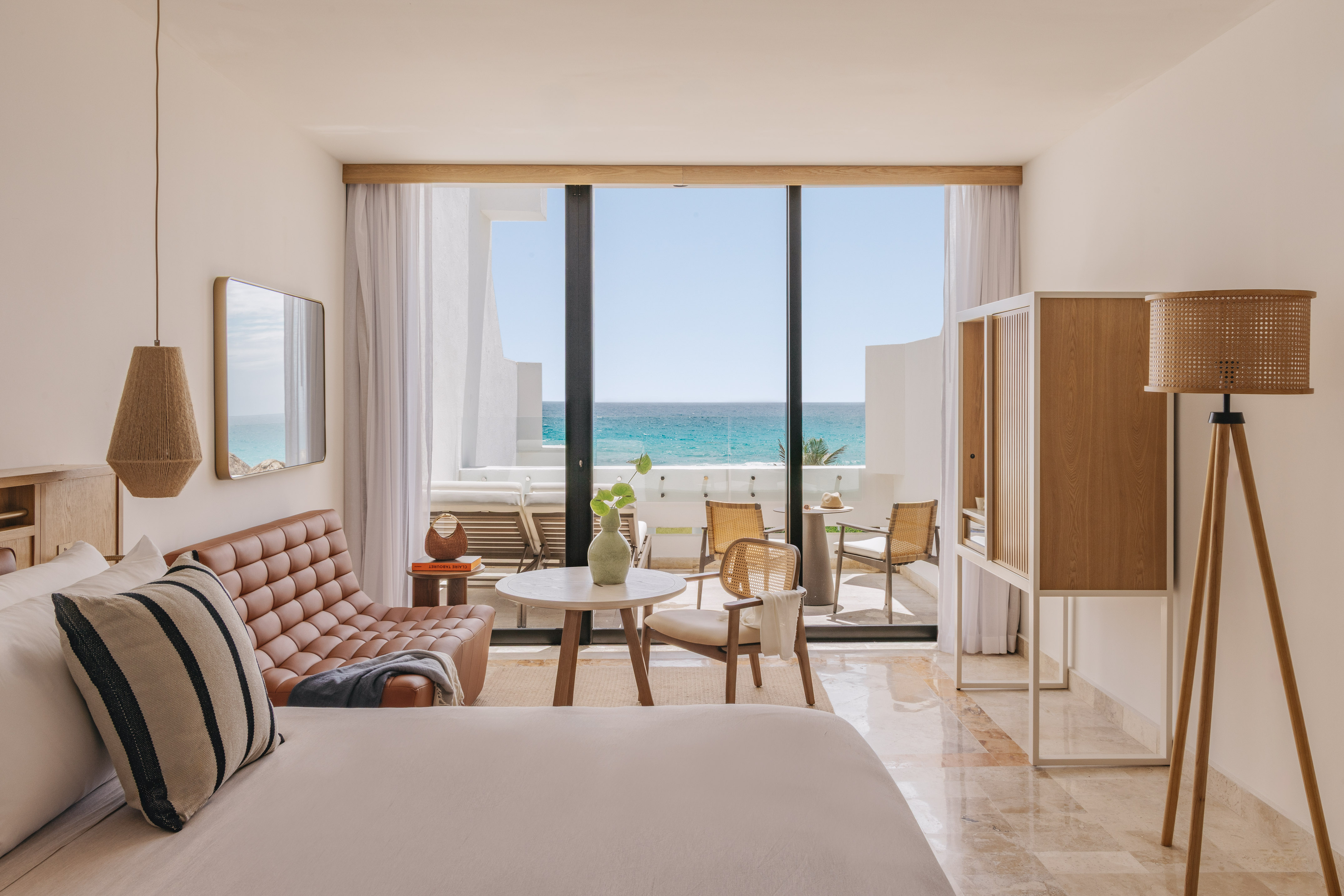 Modern ocean view resort suite with balcony and stylish decor.