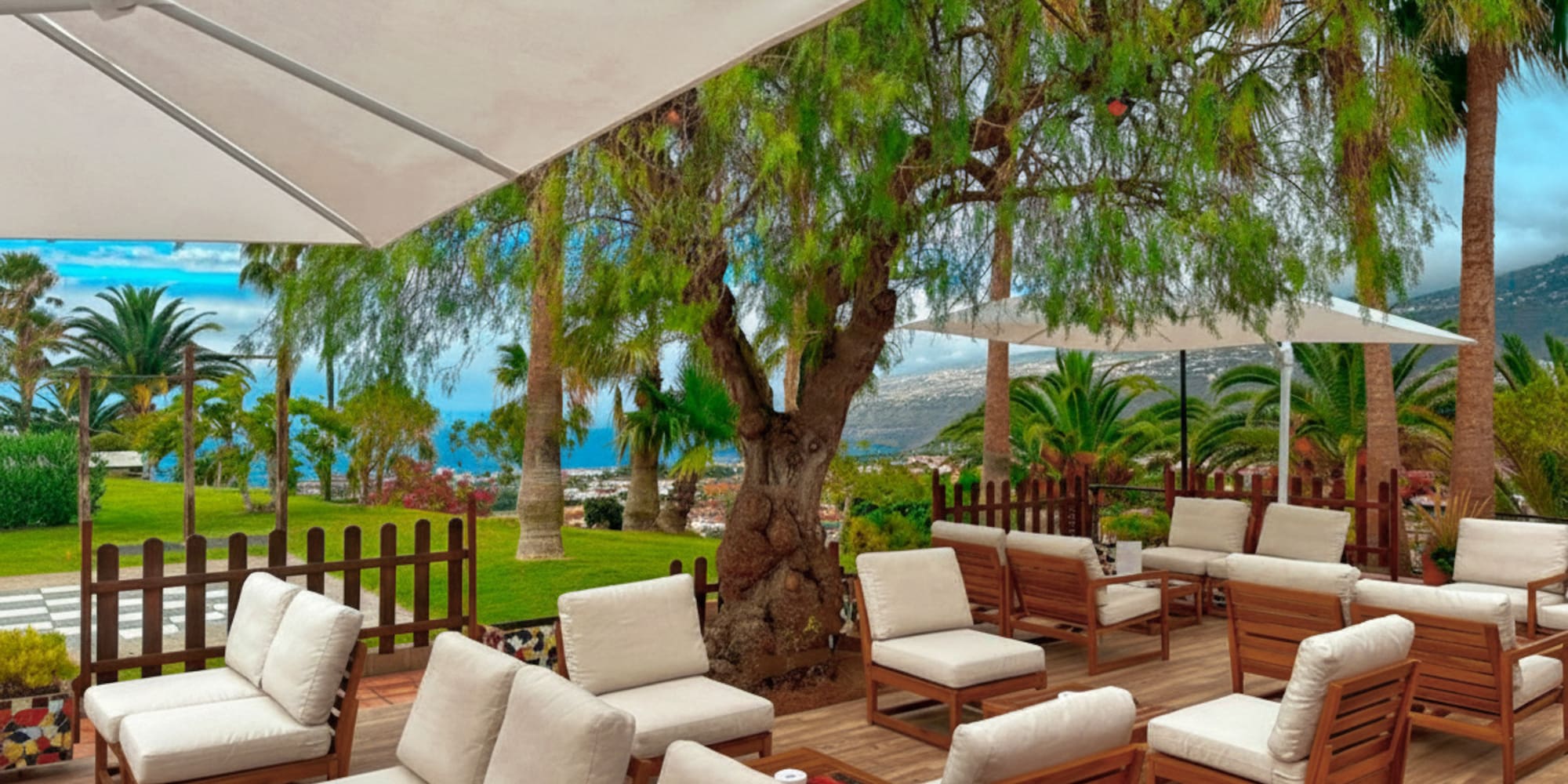 a patio with white chairs and umbrellas