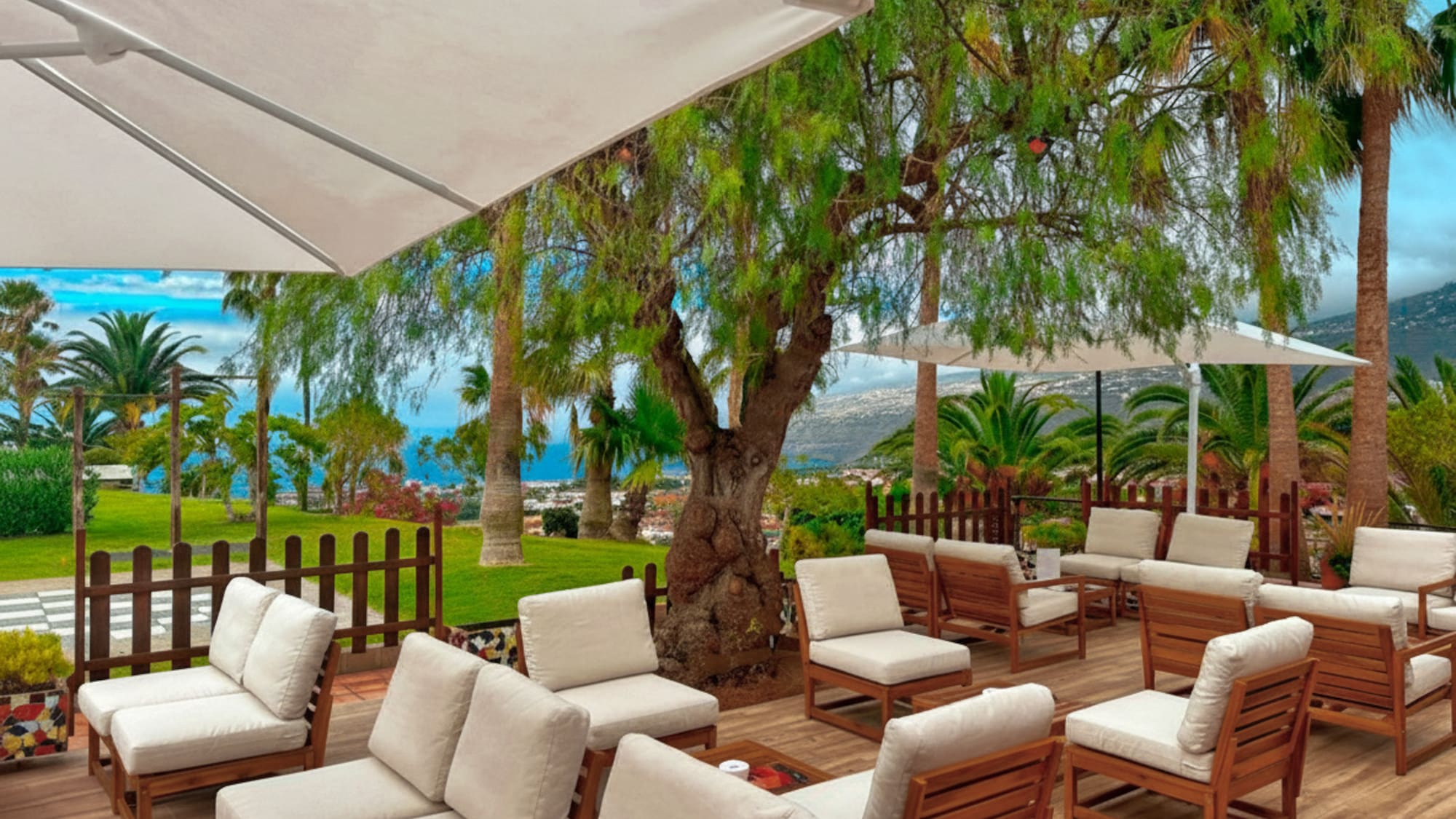 a patio with white chairs and umbrellas