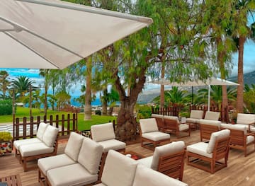 a patio with white chairs and umbrellas
