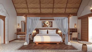 a bed with white curtains and a rug
