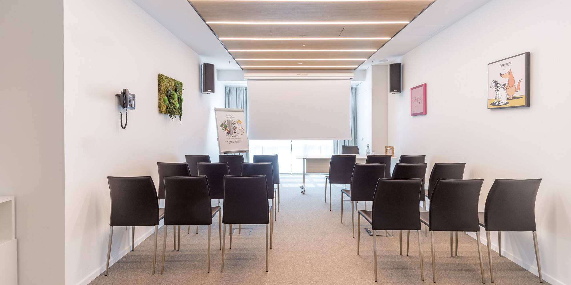 a room with chairs and a projector screen