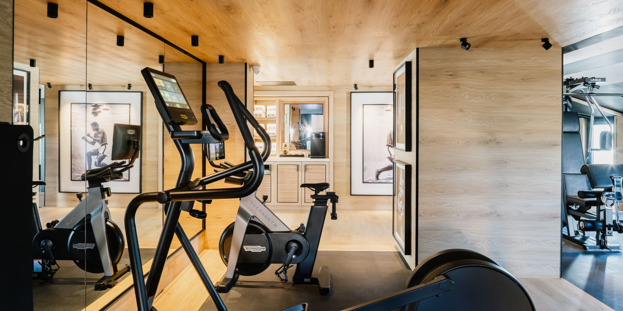 a room with exercise machines and a wood ceiling