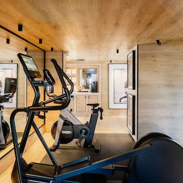 a room with exercise machines and a wood ceiling
