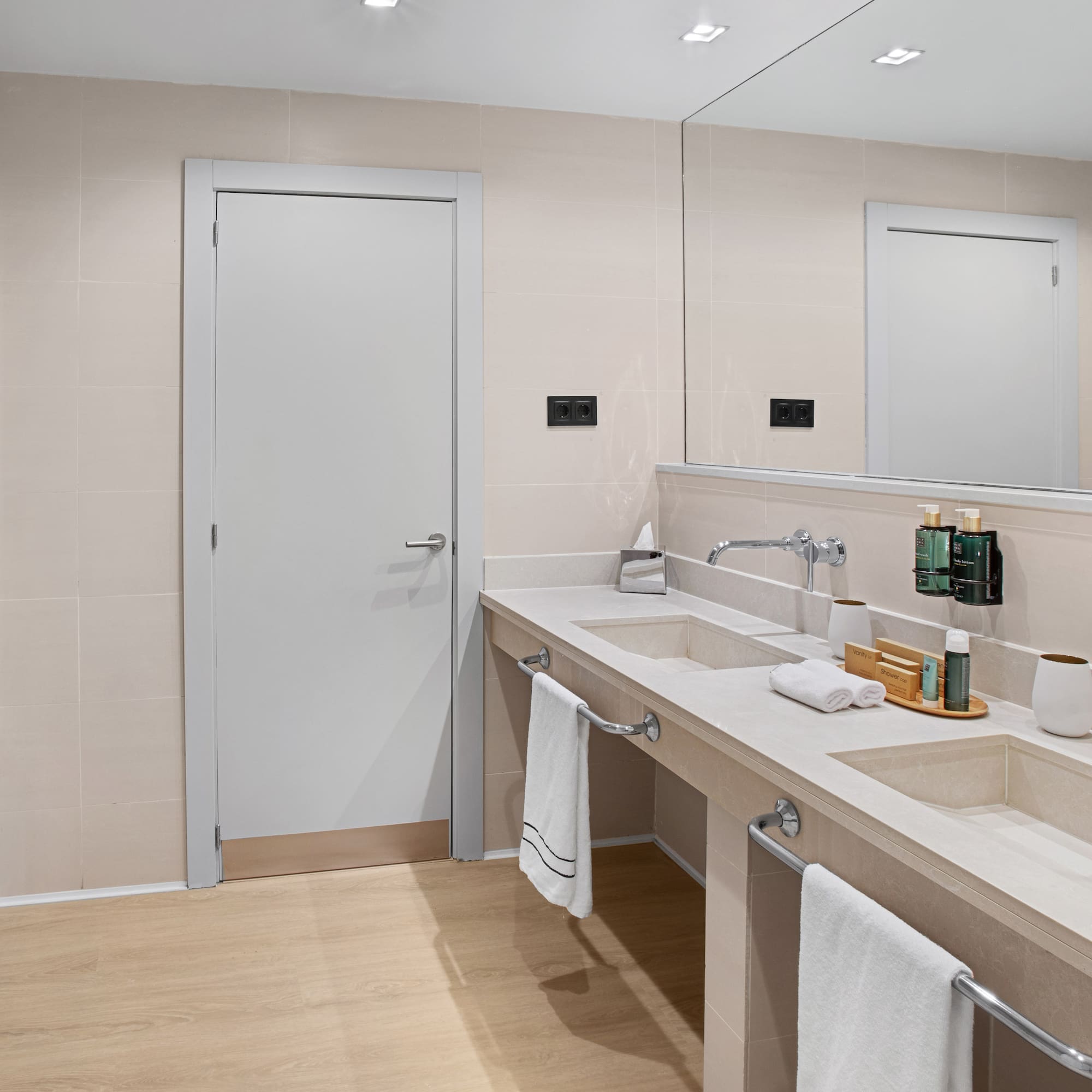 a bathroom with a double sink and a door