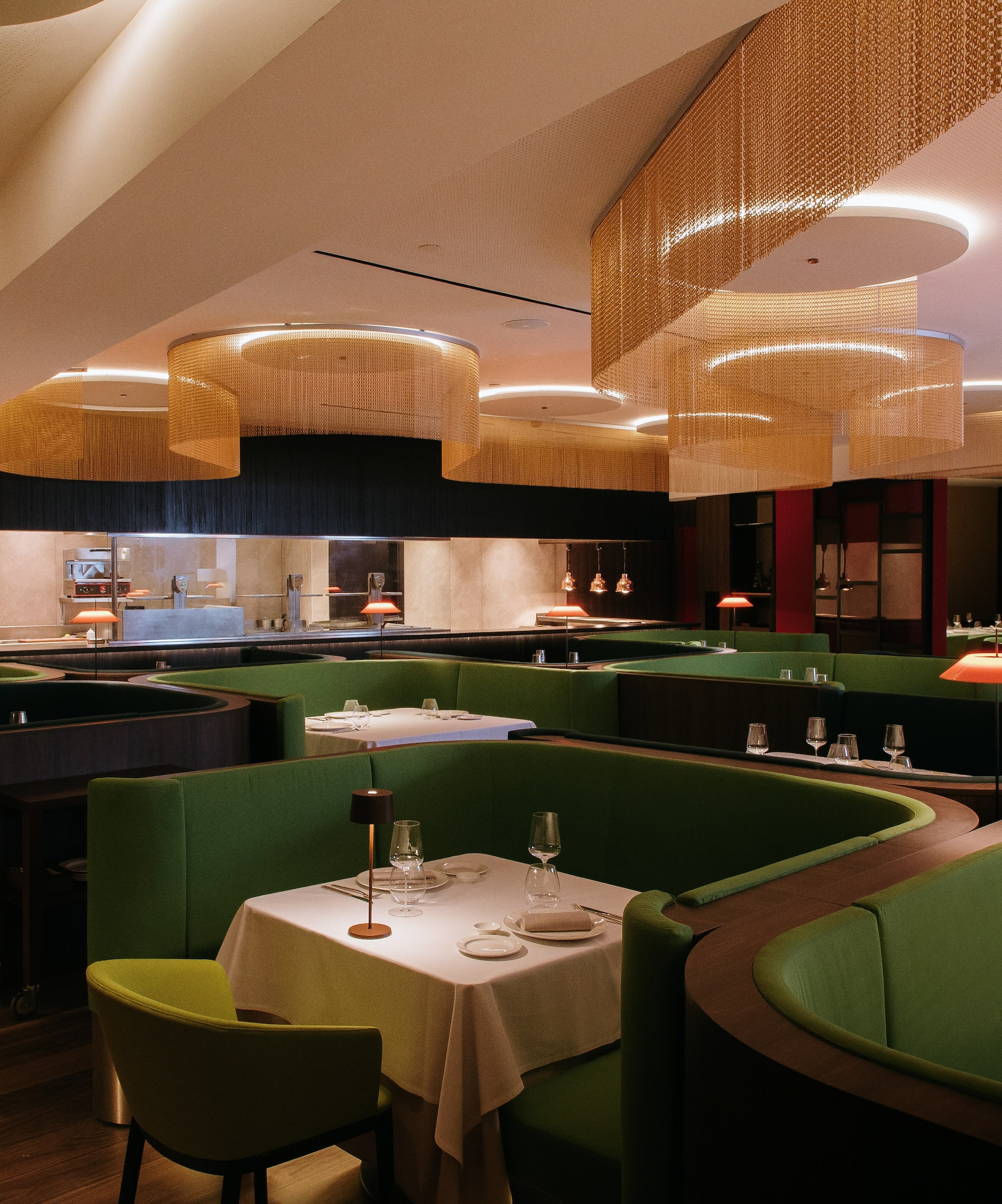 a restaurant with green couches and tables