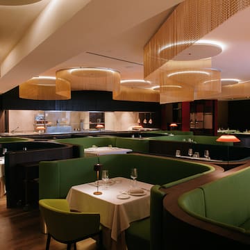 a restaurant with green couches and tables