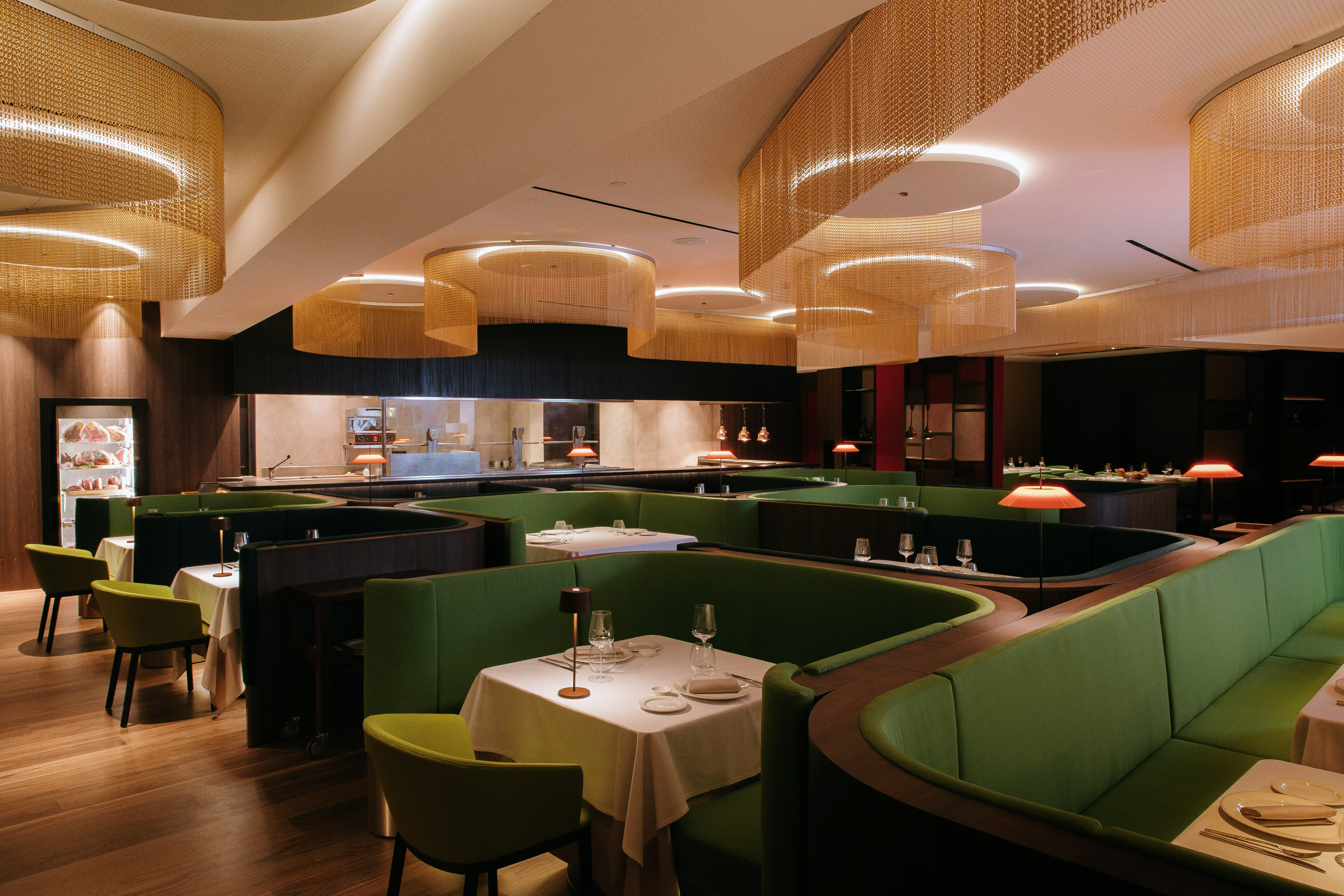 a restaurant with green couches and tables