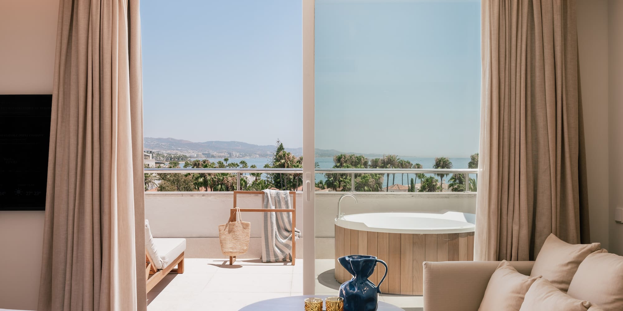 a room with a view of the ocean and a jacuzzi