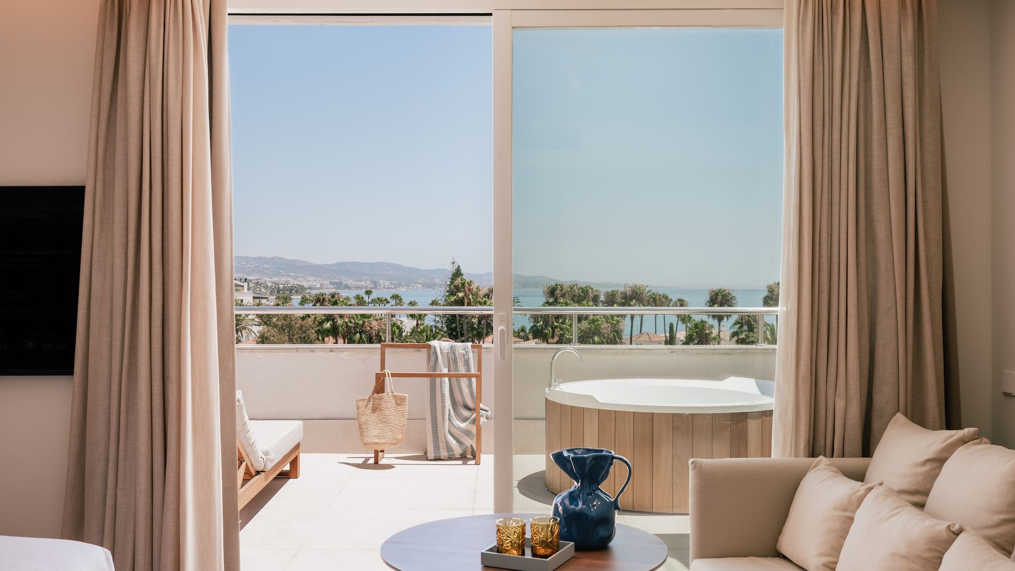 a room with a view of the ocean and a jacuzzi