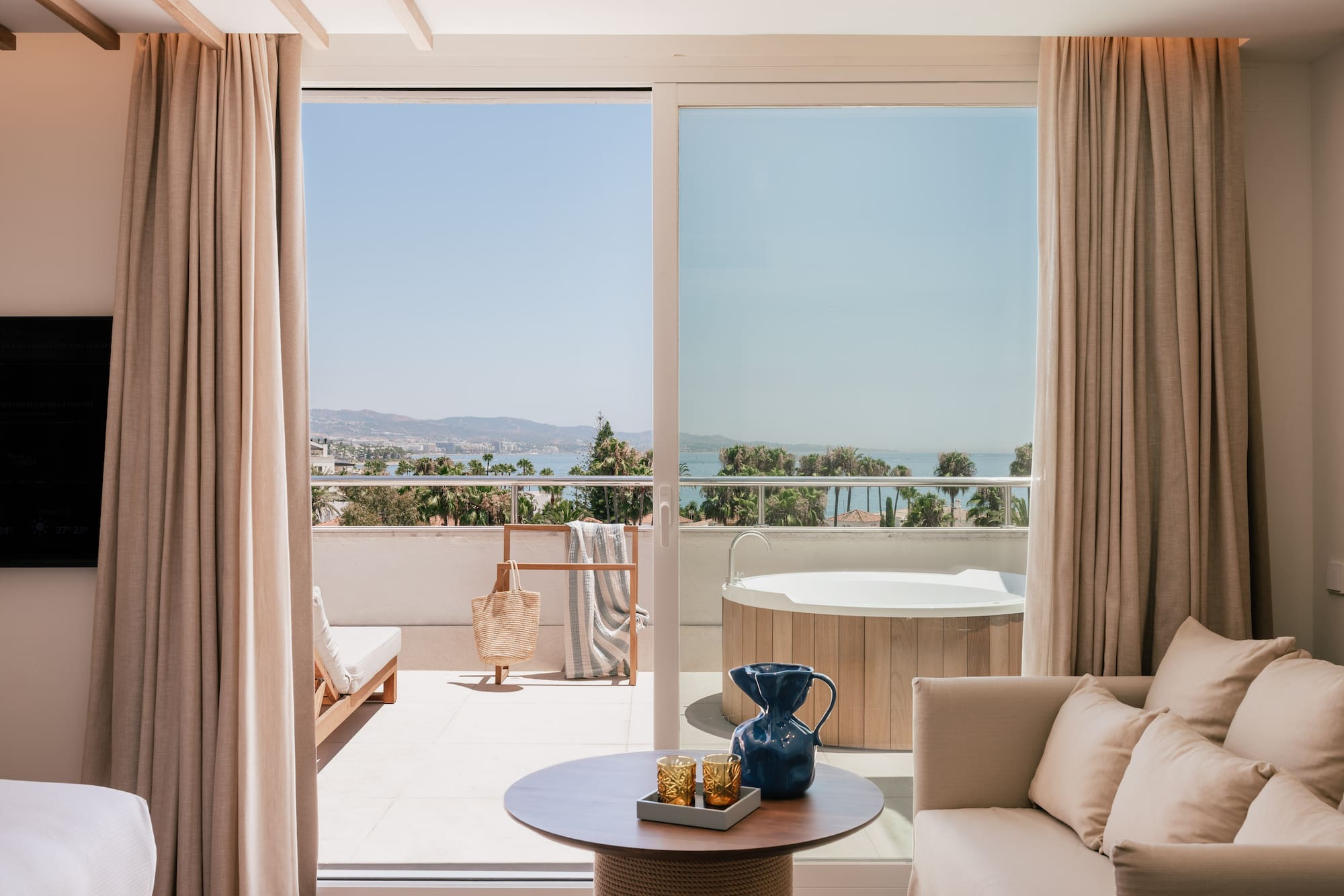 a room with a view of the ocean and a jacuzzi