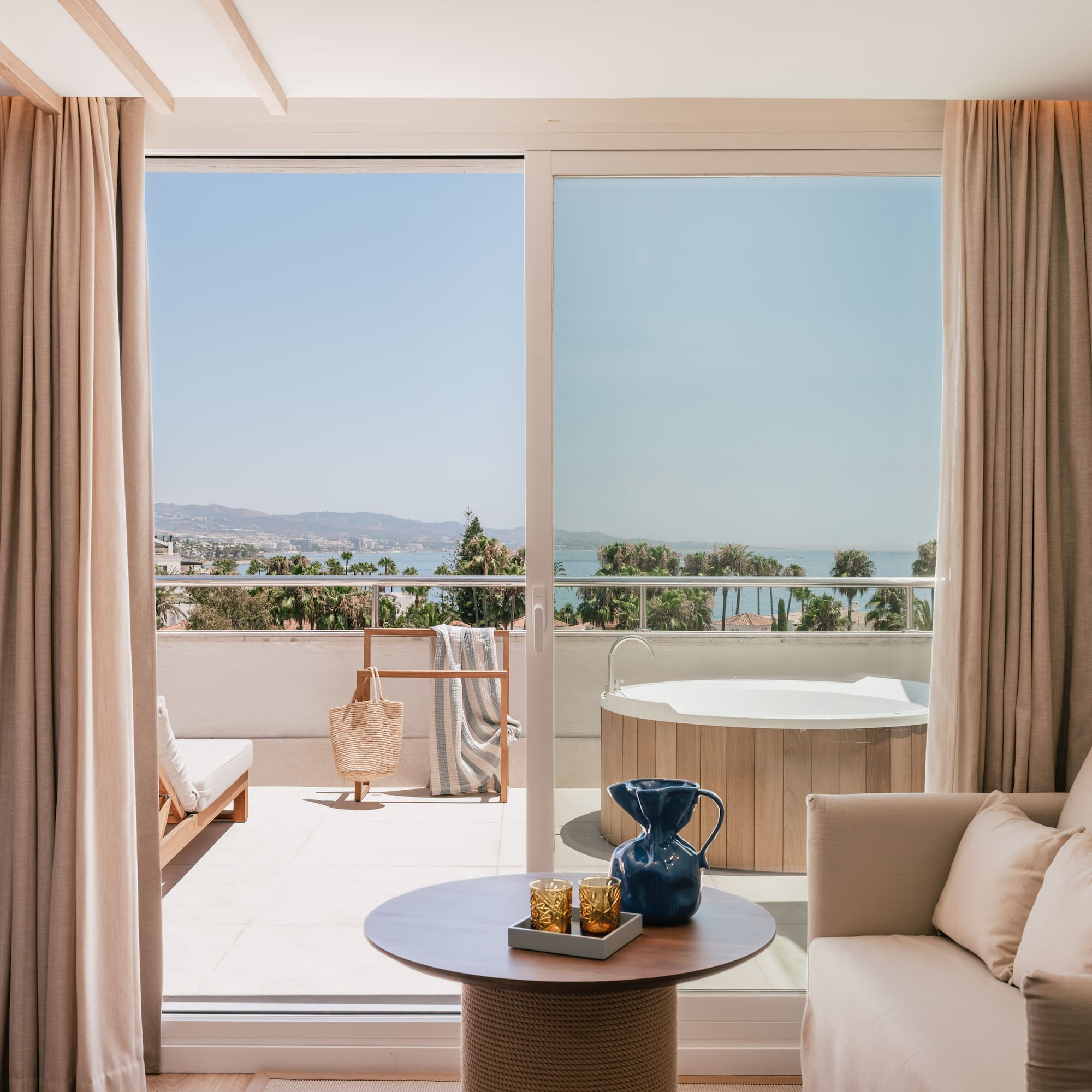 a room with a view of the ocean and a jacuzzi