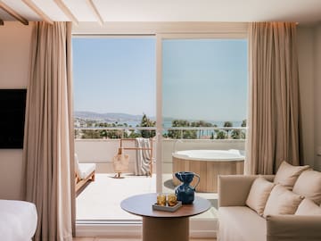 a room with a view of the ocean and a jacuzzi