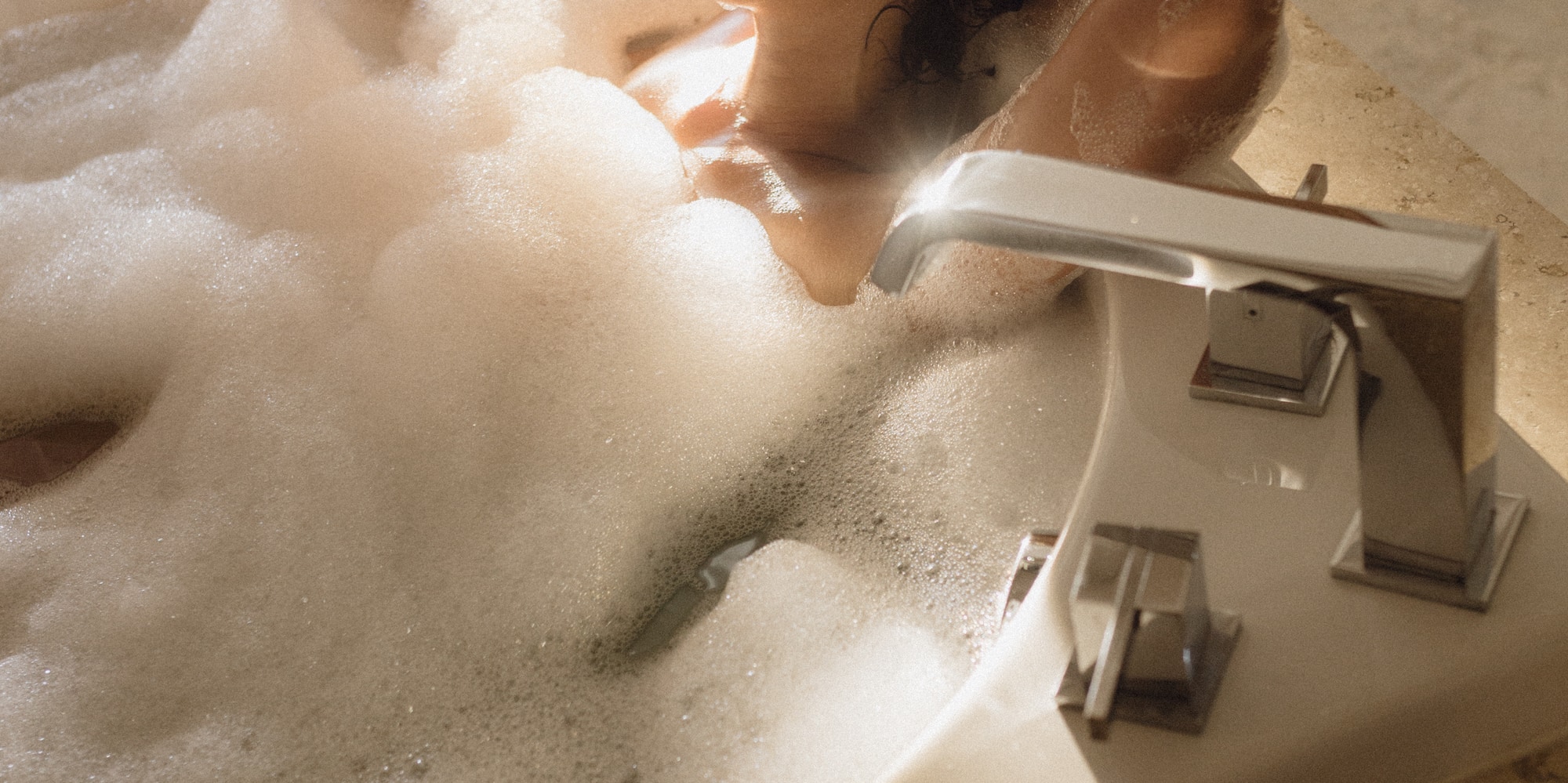 a woman in a bathtub holding a glass of wine