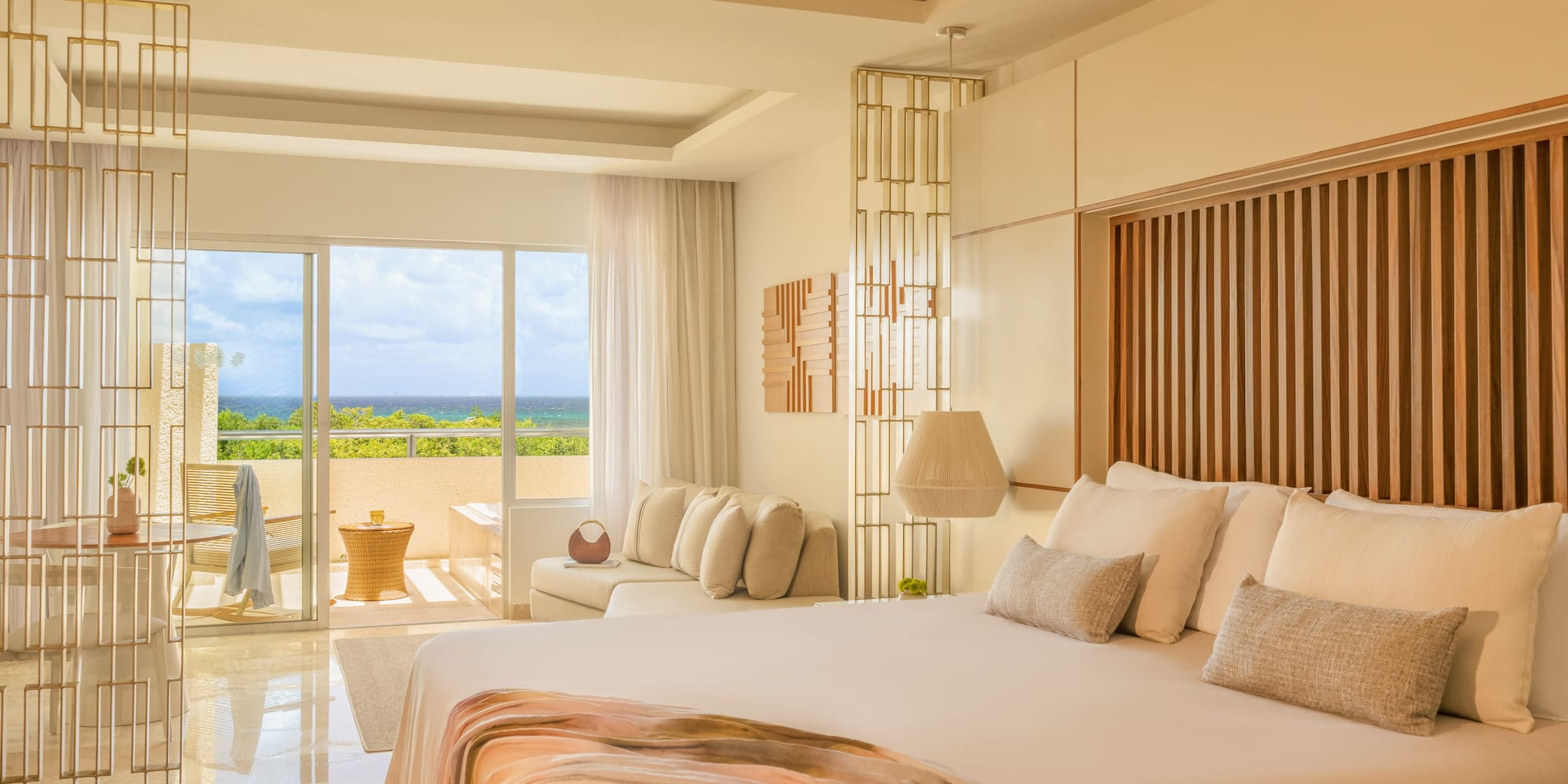 Modern luxury bedroom with ocean view, balcony, and king-size bed.