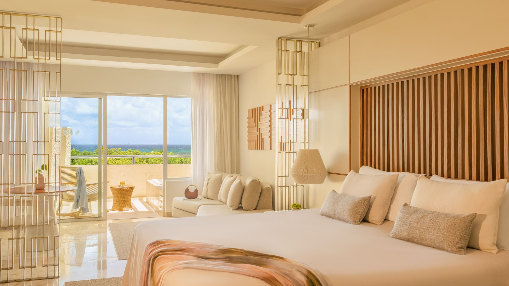Modern luxury bedroom with ocean view, balcony, and king-size bed.