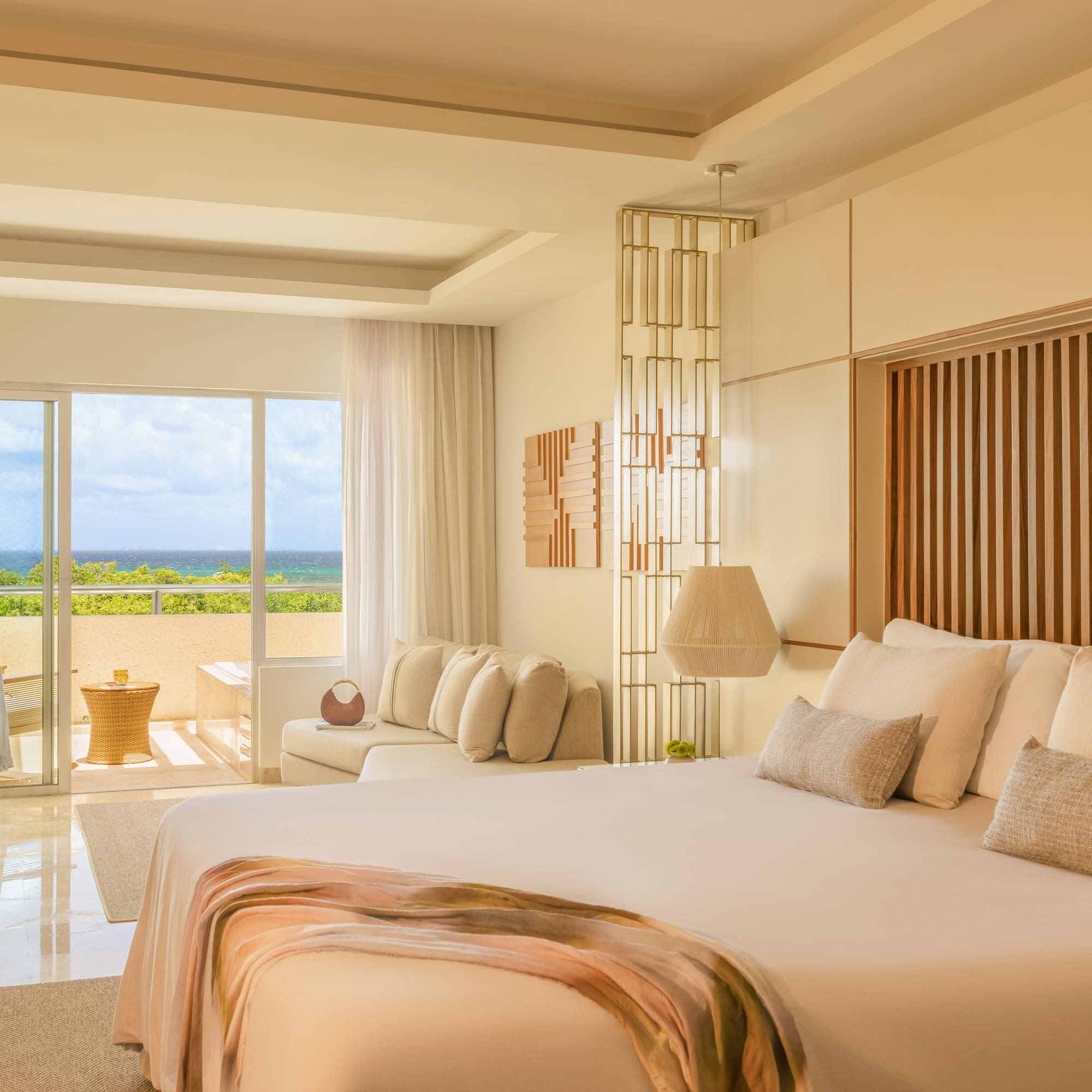 Modern luxury bedroom with ocean view, balcony, and king-size bed.