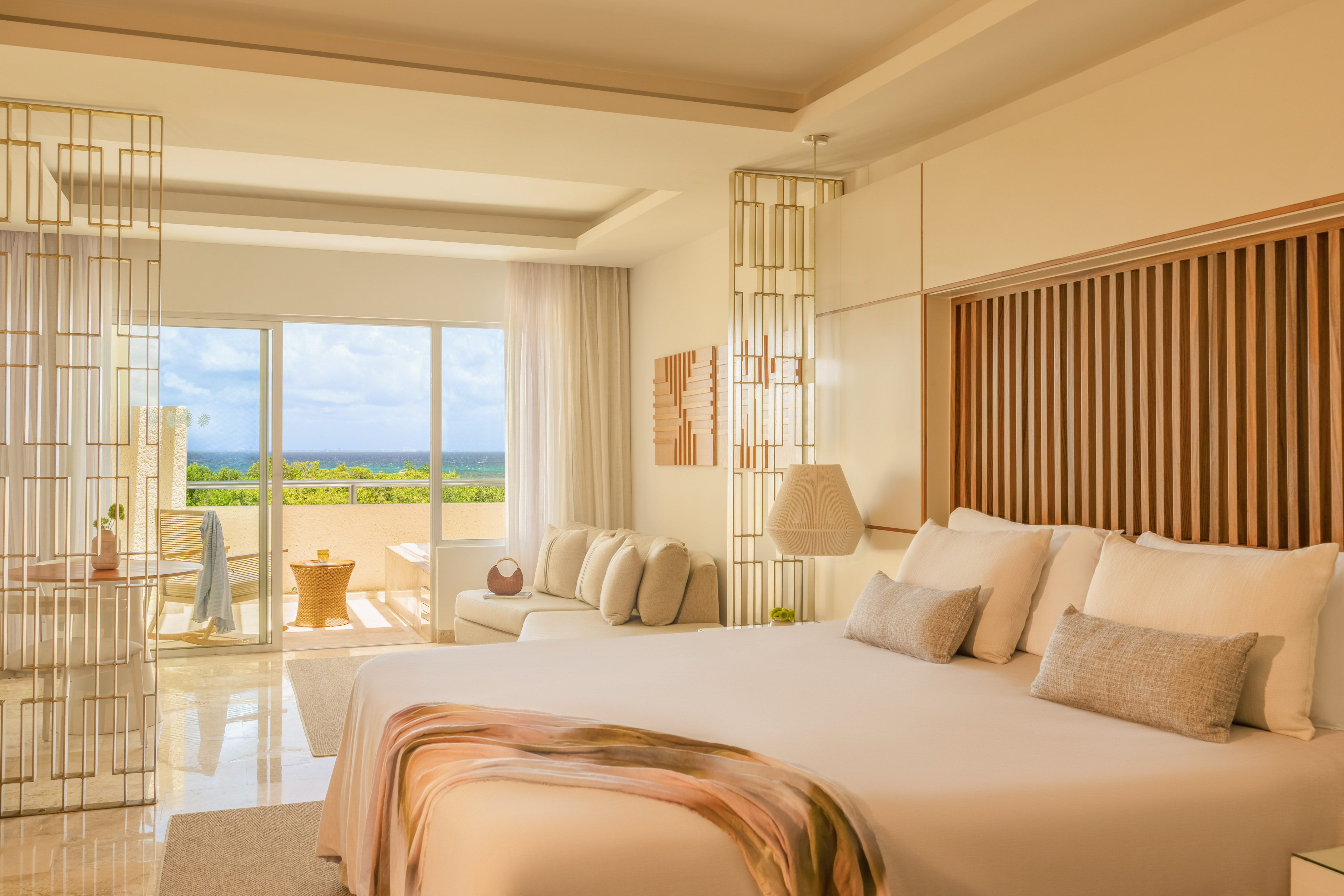 Modern luxury bedroom with ocean view, balcony, and king-size bed.