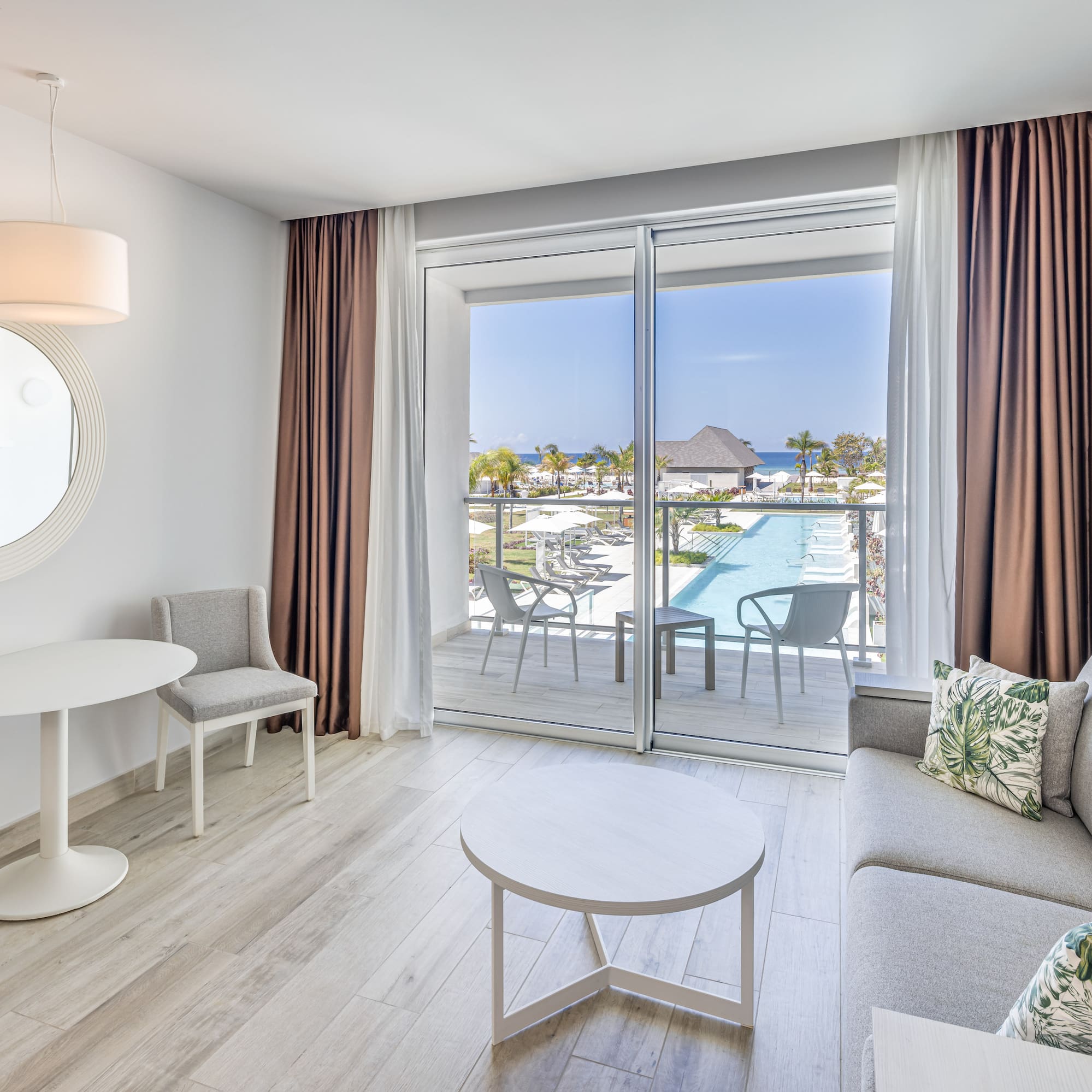 a living room with a glass door and a pool in the background