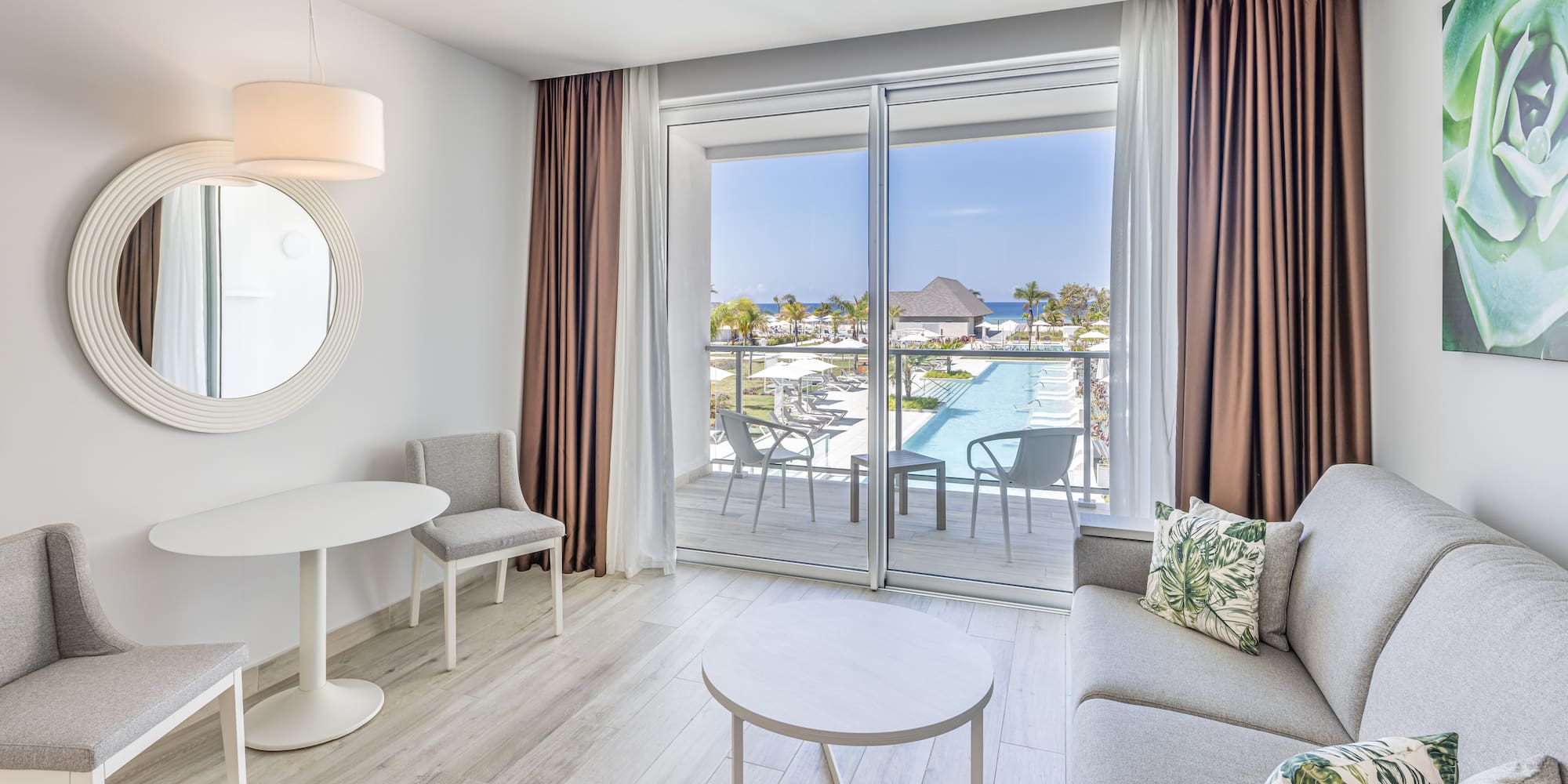 a living room with a glass door and a pool in the background