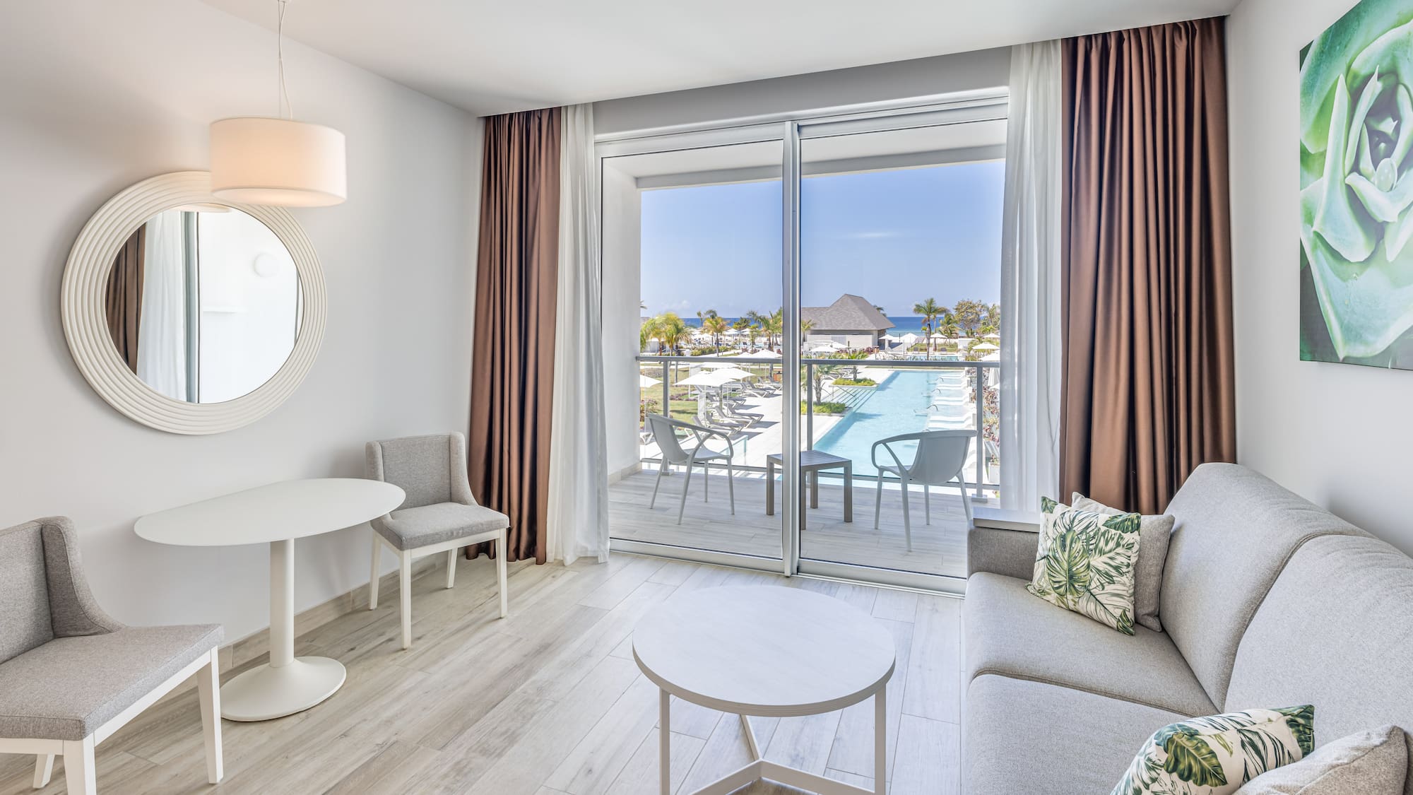 a living room with a glass door and a pool in the background