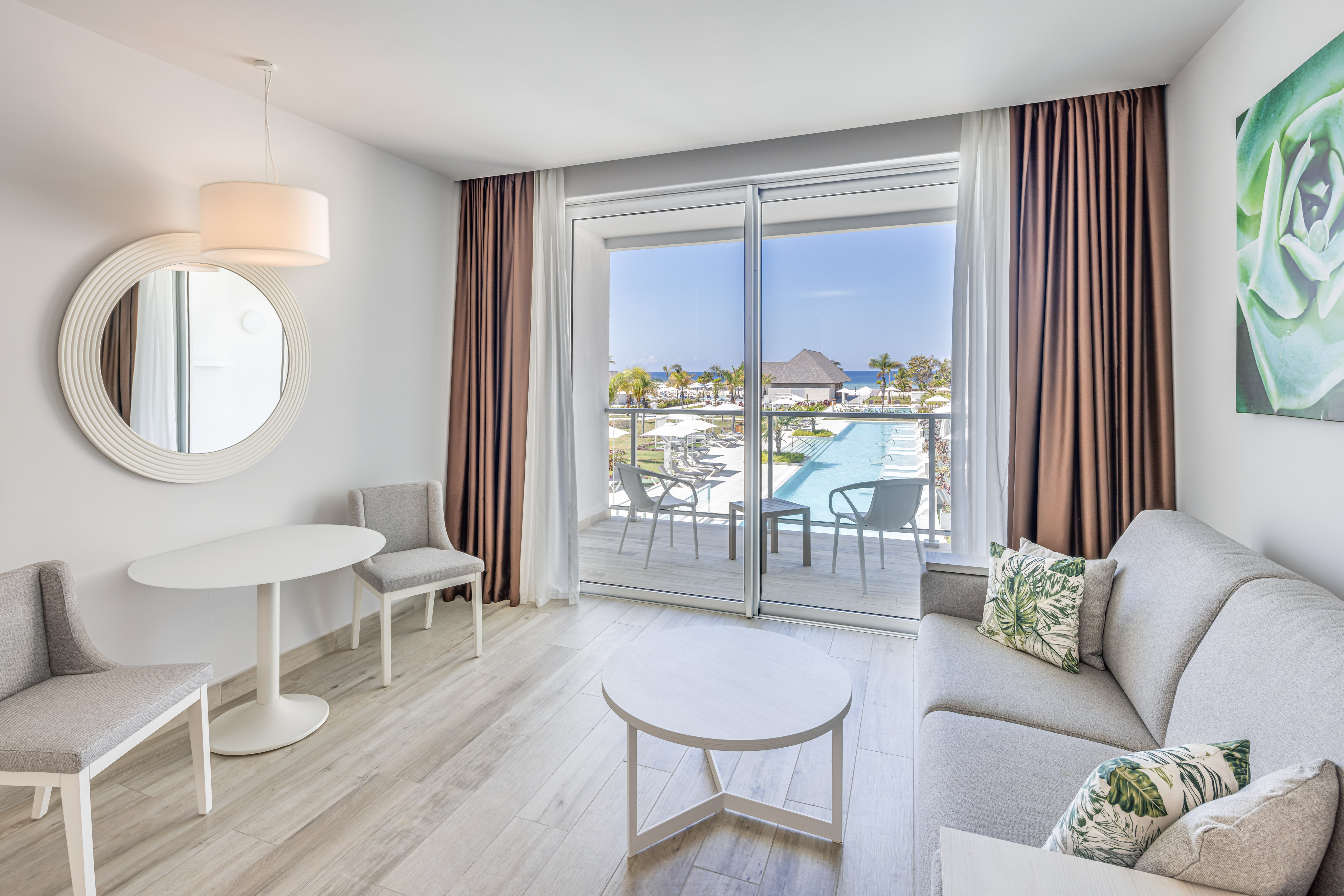 a living room with a glass door and a pool in the background