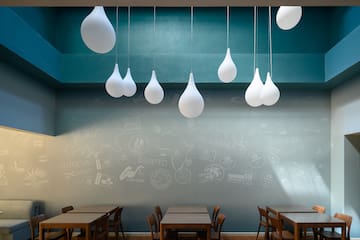 a room with tables and chairs and white balloons