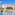 Sunny resort water park with colorful slides, splash zone, pool, and hotel.