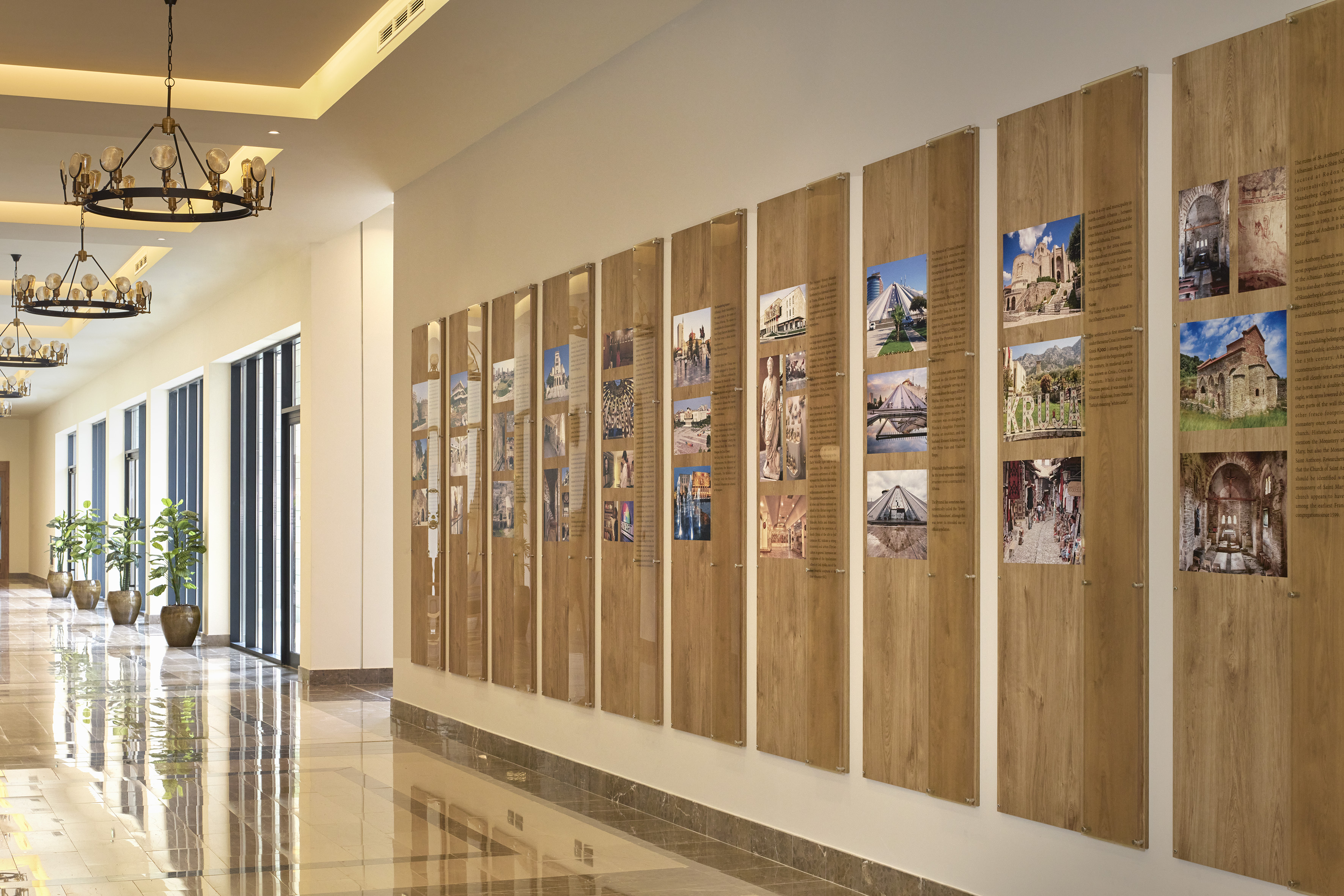 Modern corridor featuring historical exhibit displays and ornate chandeliers.