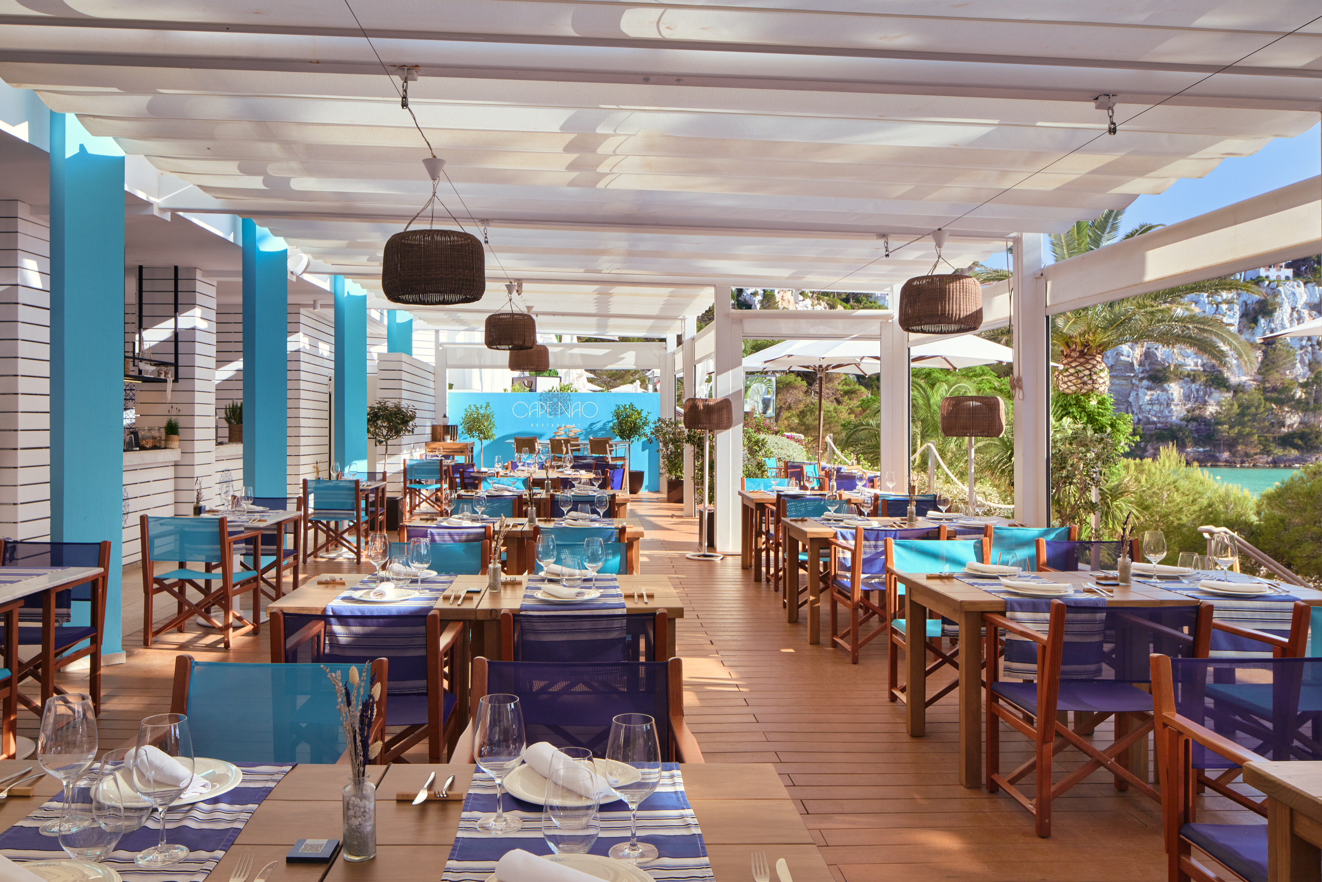 Cape Nao outdoor restaurant terrace, blue and white tables set, bay view.