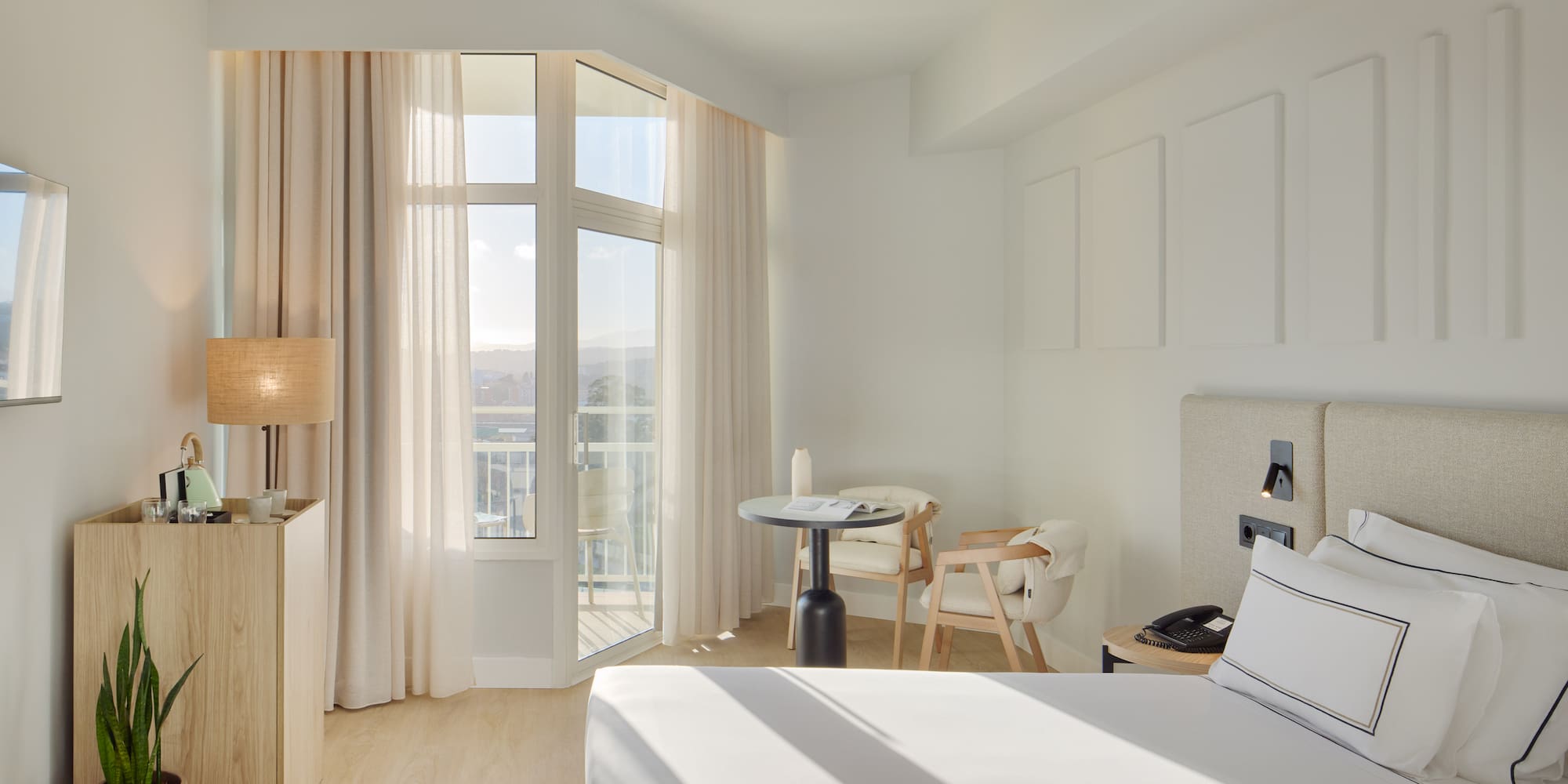 a room with a bed and a table and chairs