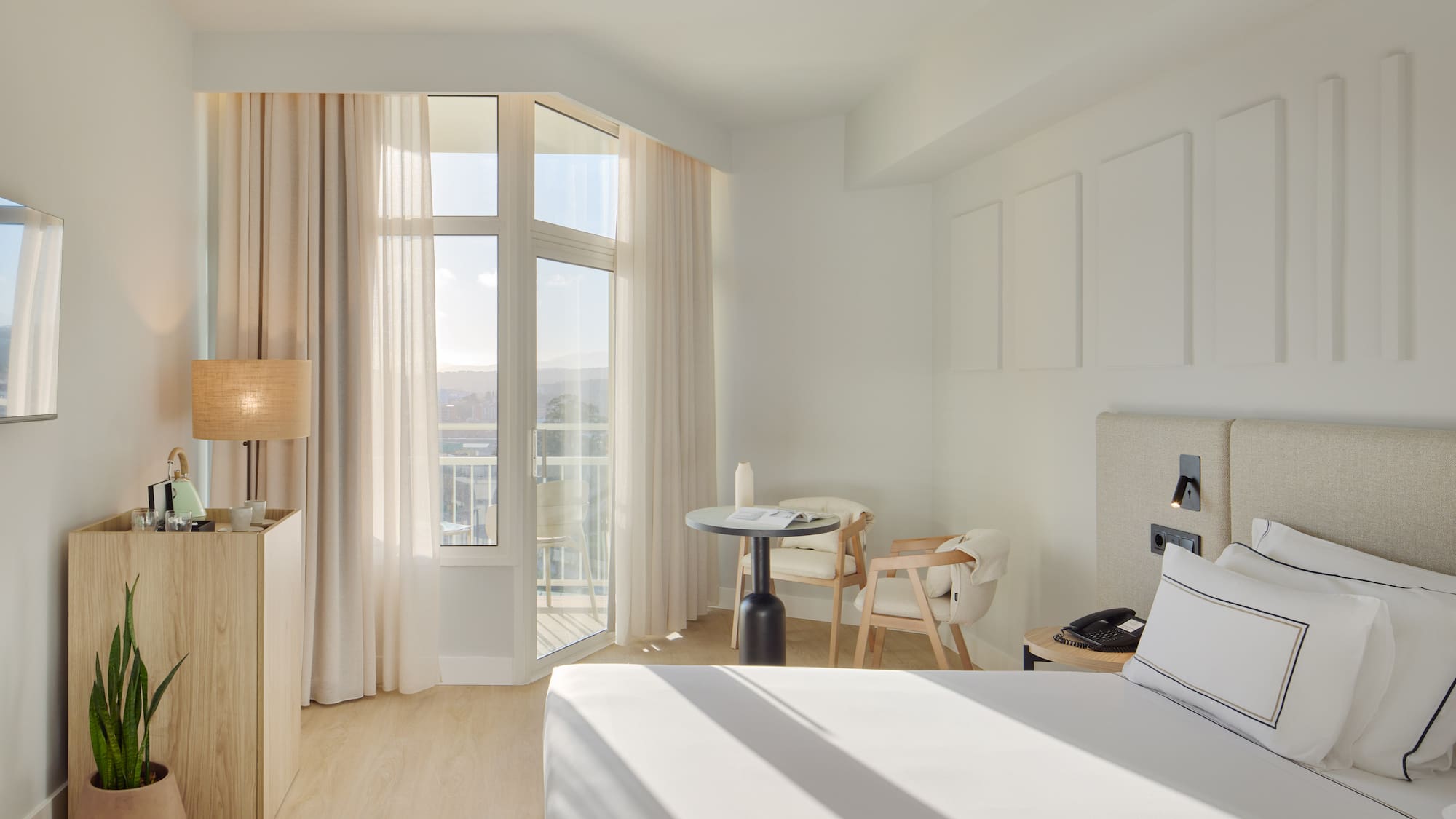 a room with a bed and a table and chairs