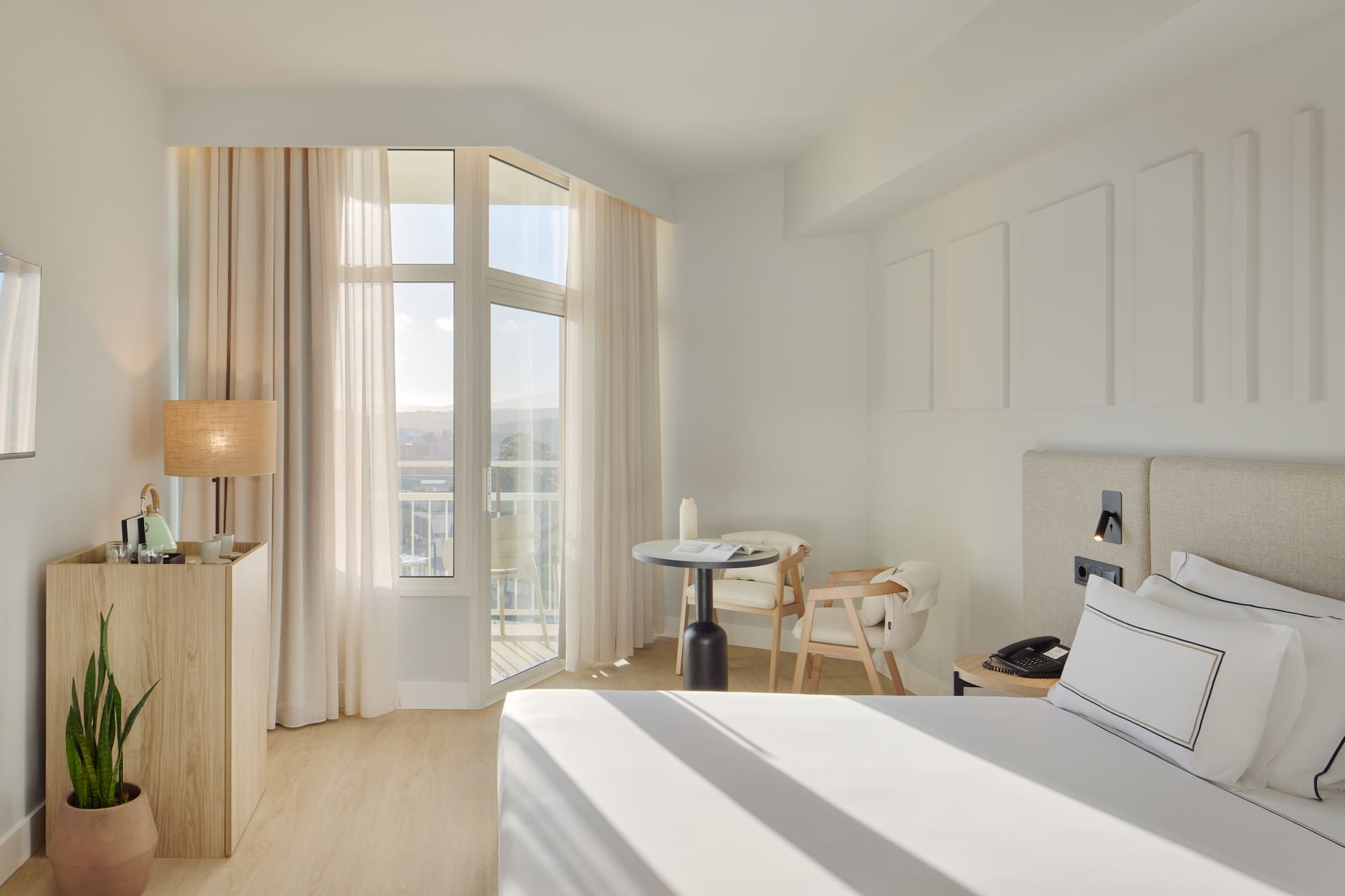 a room with a bed and a table and chairs