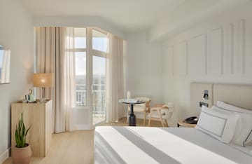 a room with a bed and a table and chairs