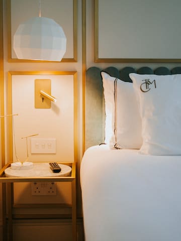 a bed with pillows and a lamp next to a table
