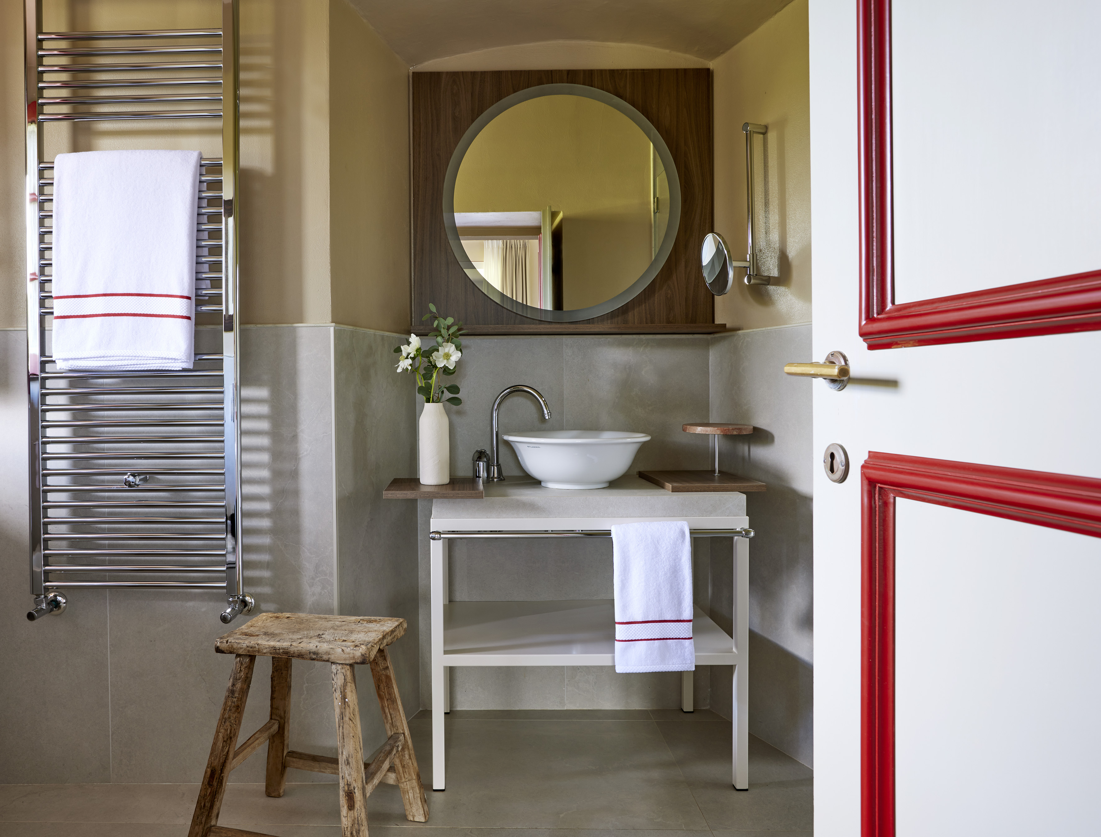 a bathroom with a round mirror and sink