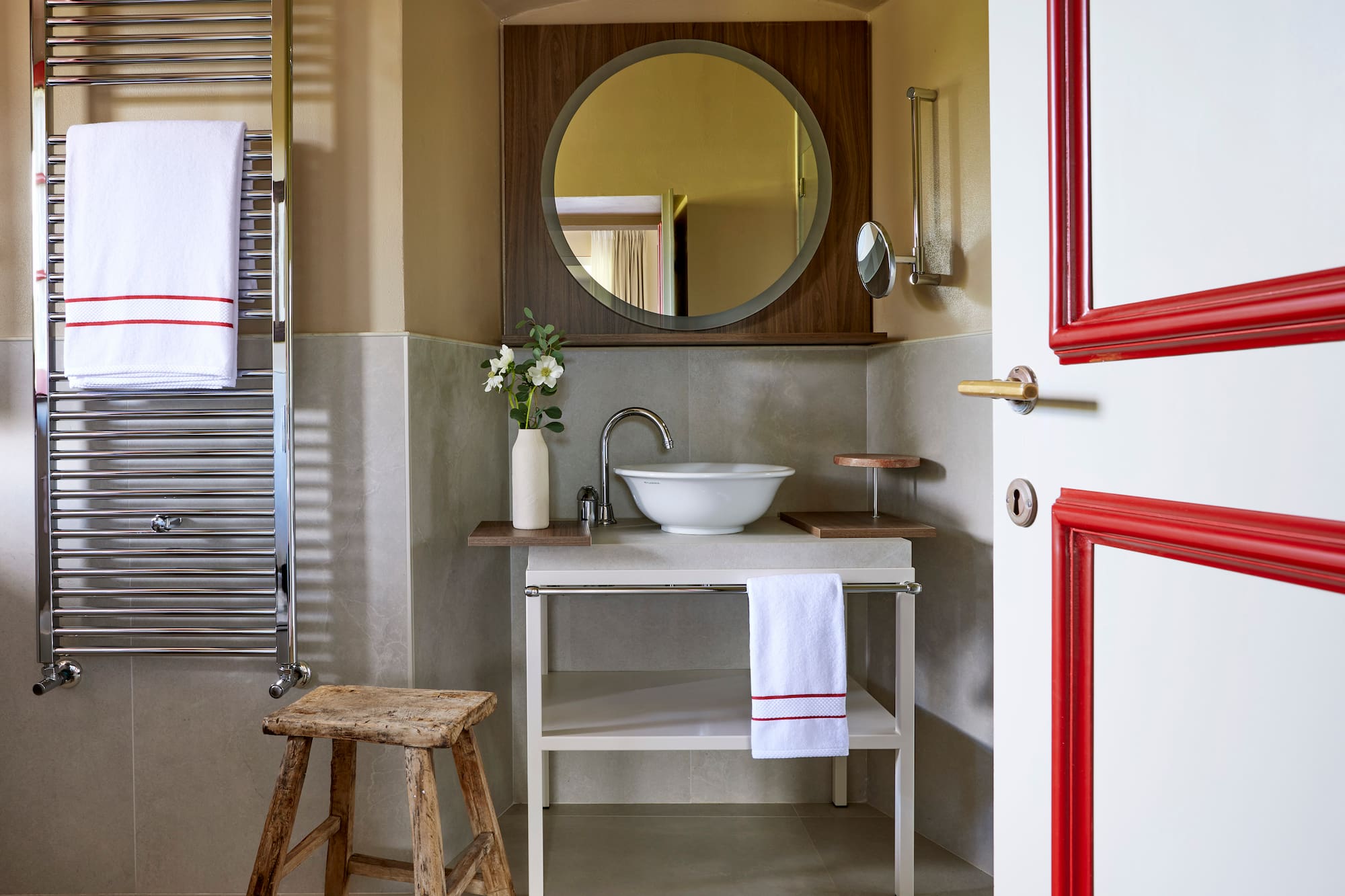 a bathroom with a round mirror and sink