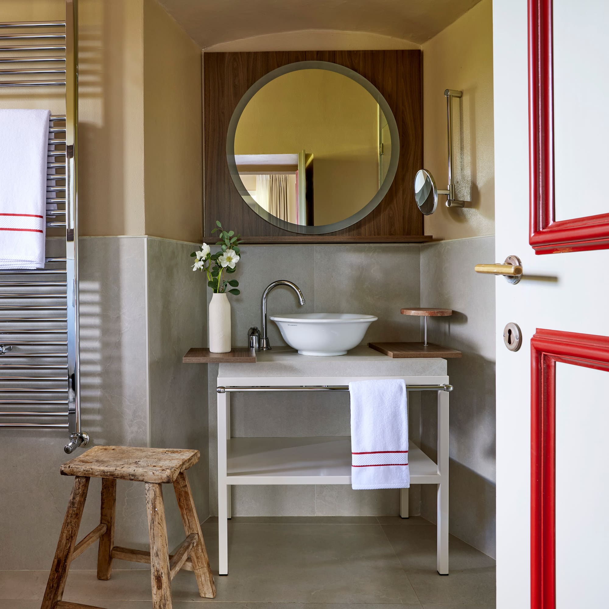 a bathroom with a round mirror and sink