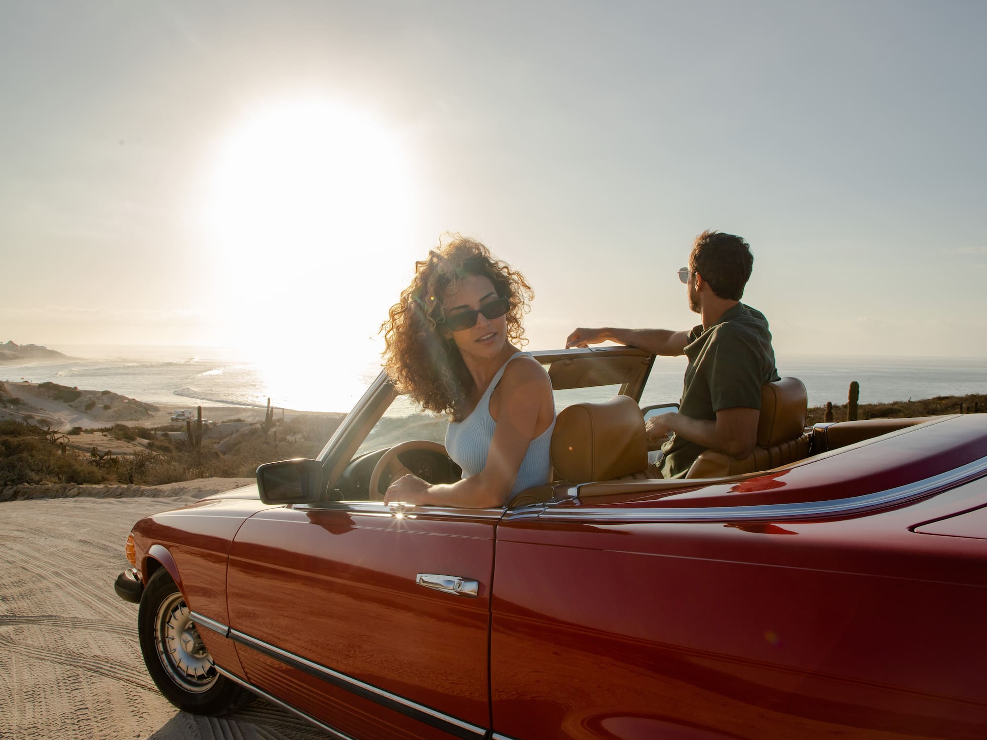 a man and woman in a convertible car