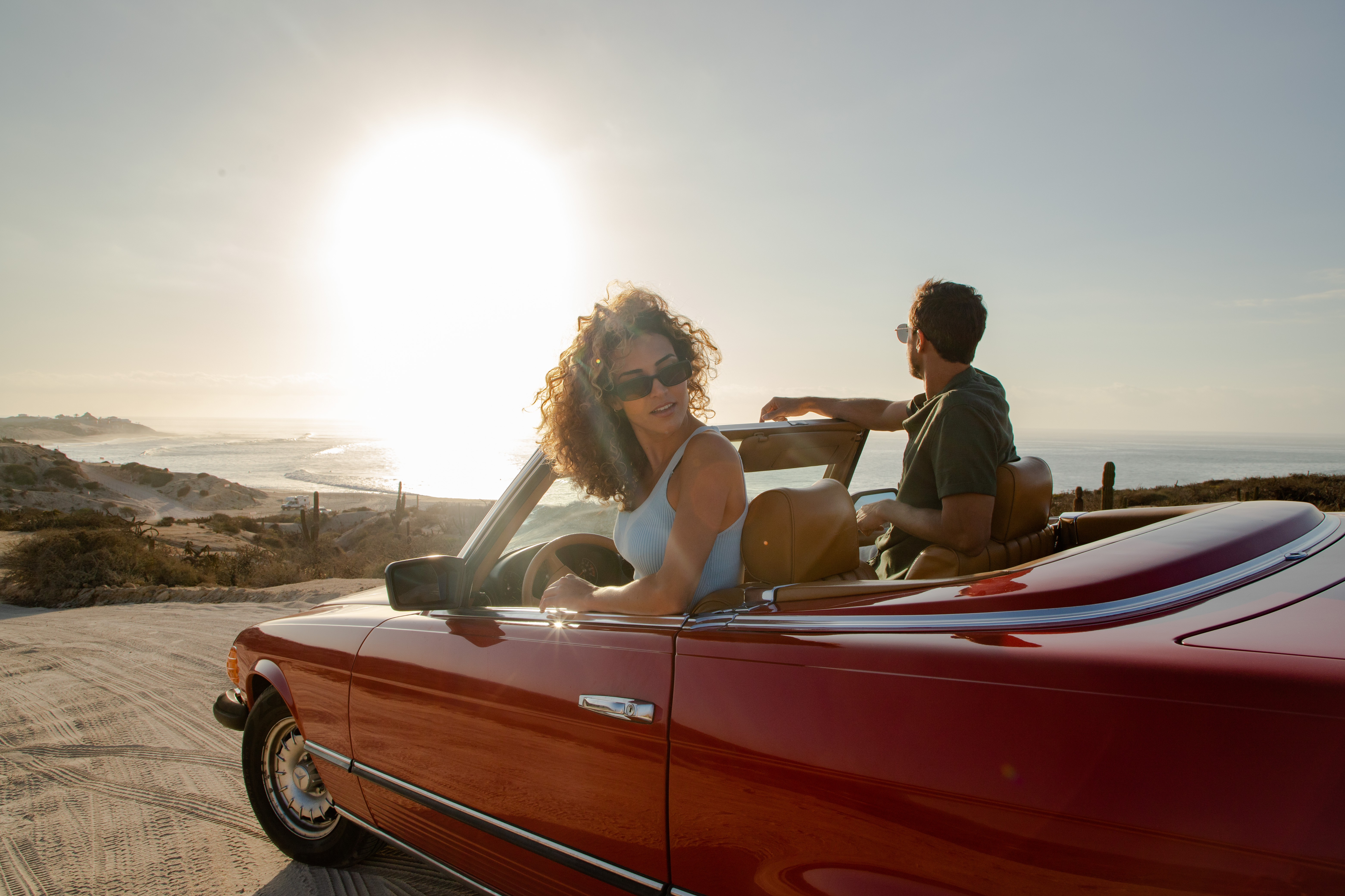 a man and woman in a convertible car
