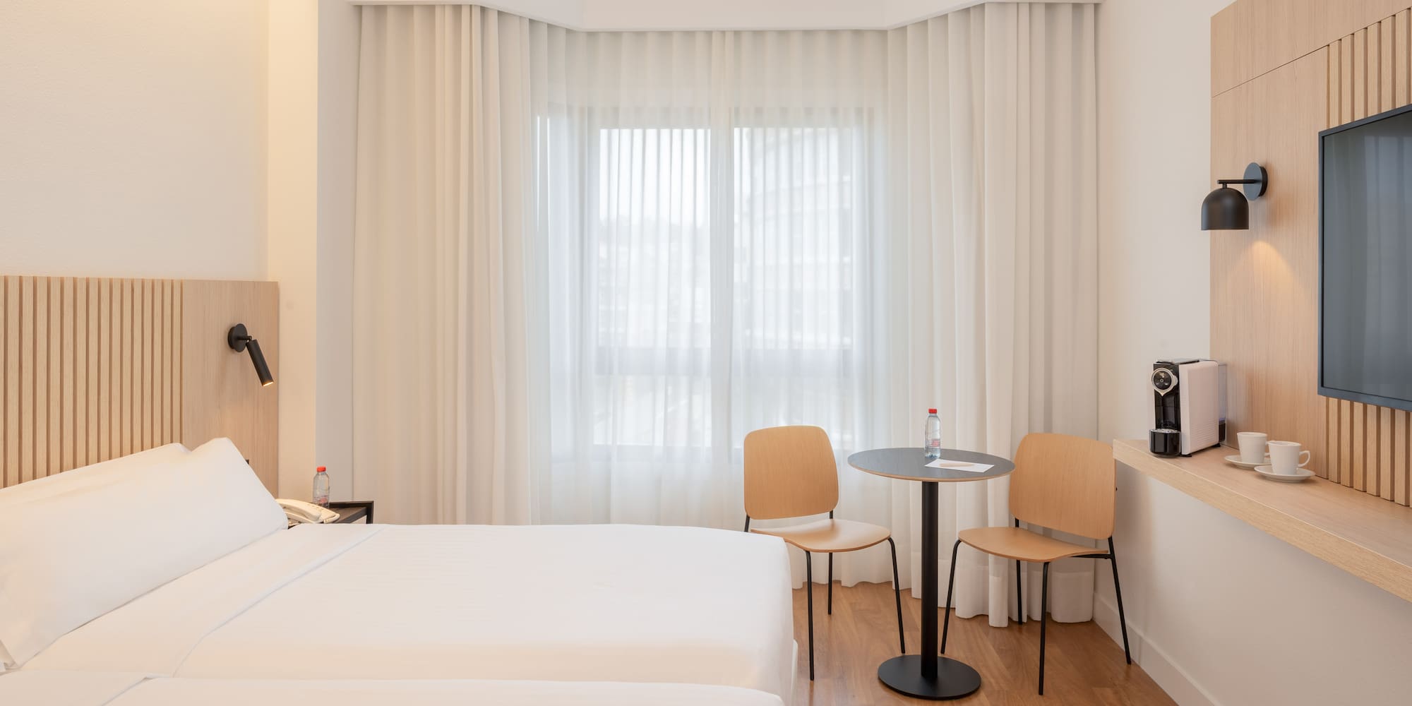 a room with two beds and a table and chairs