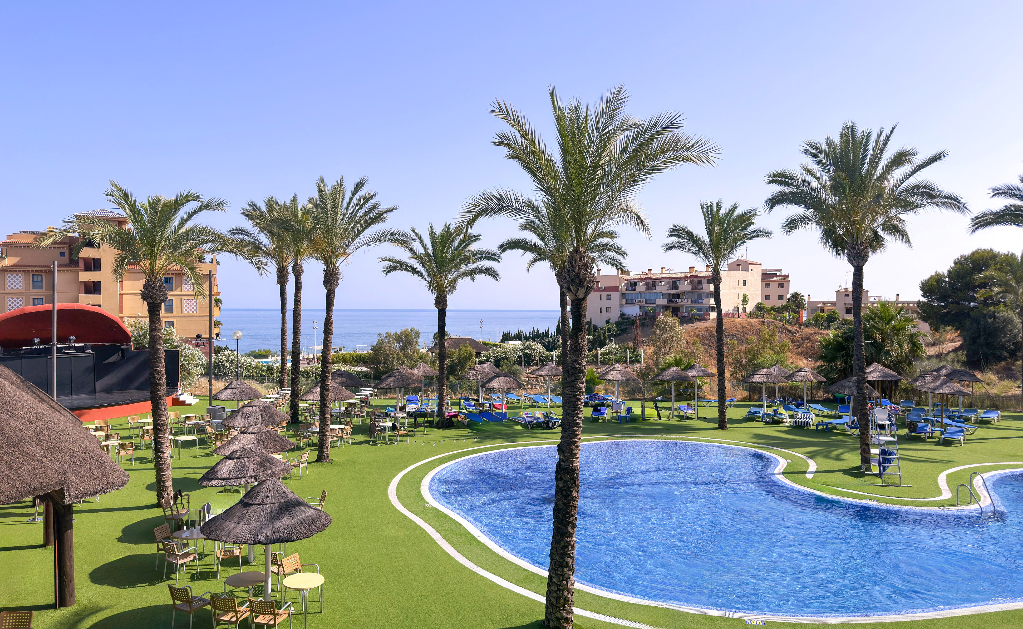 a pool with umbrellas and chairs and palm trees