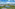 Overhead view of tropical resort, lake, palm-lined villas, and mountains.