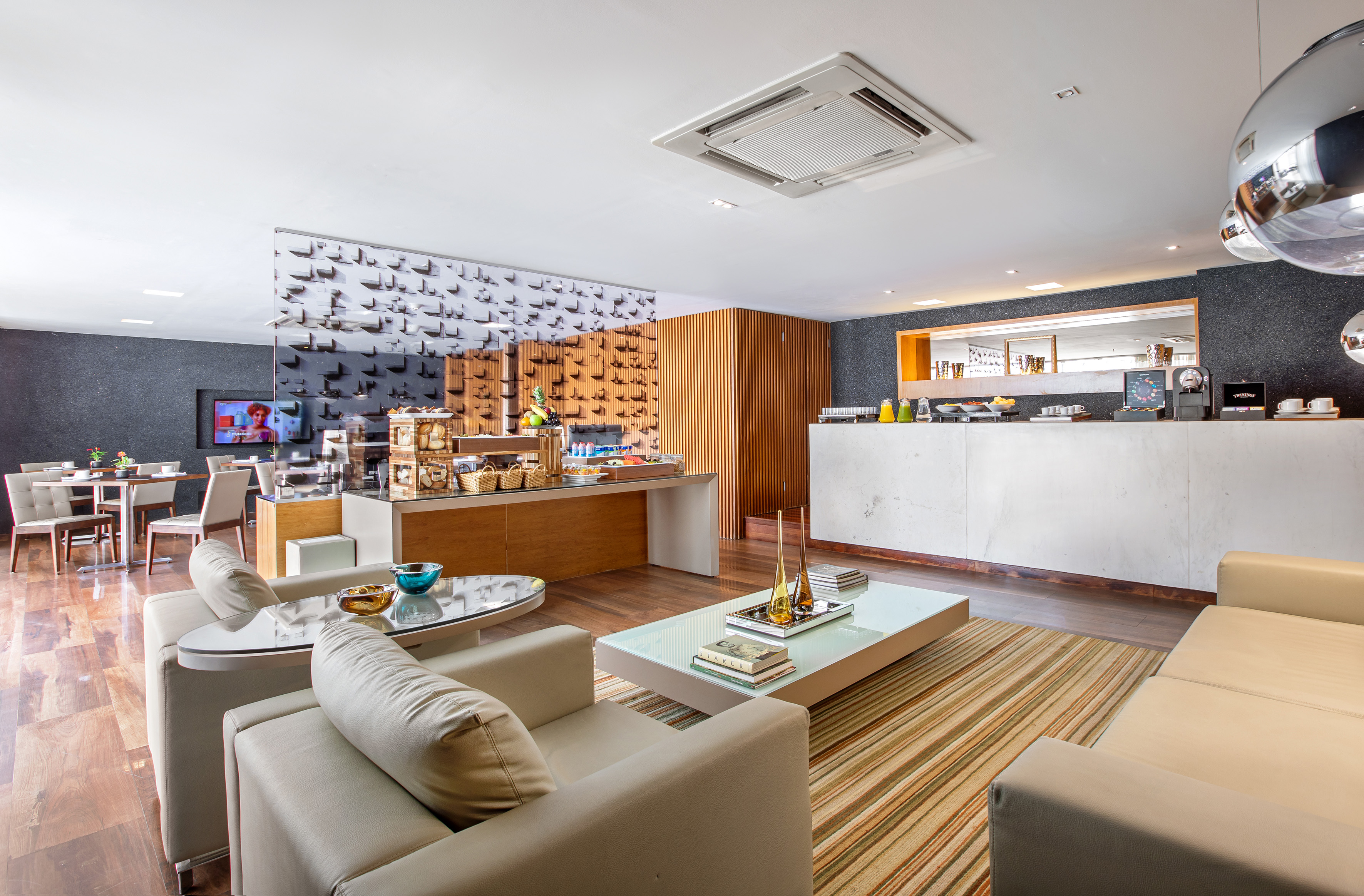 Stylish hotel lobby with breakfast bar, seating, and modern decor.