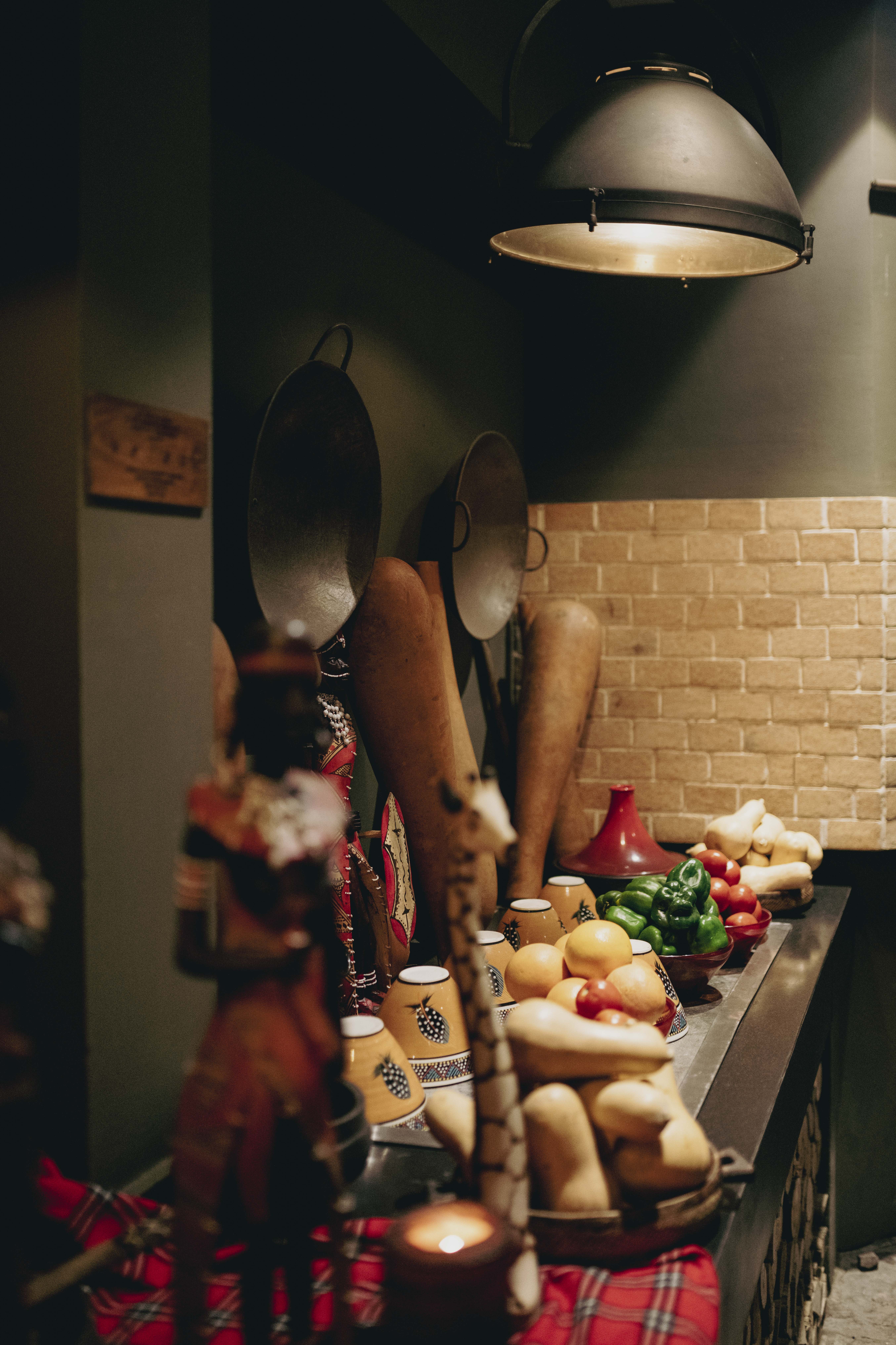 African restaurant counter with fresh produce, ethnic decor, and ambient lighting.