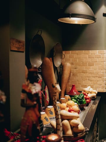 a kitchen counter with various vegetables and pots and pans
